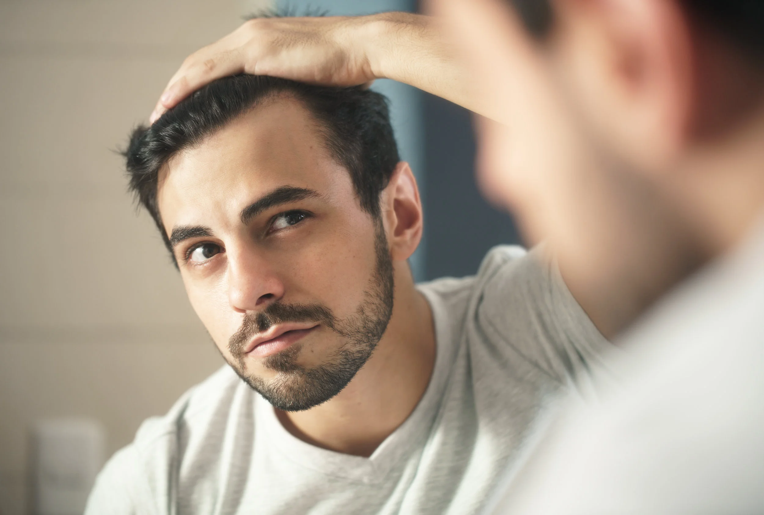 man-worried-for-alopecia-checking-hair-for-loss-324FTZN.jpg