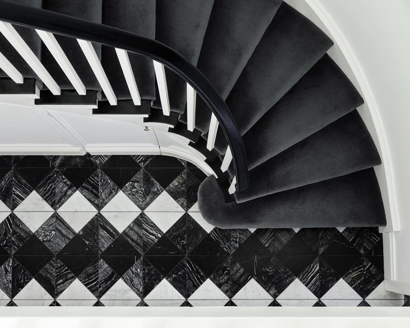 The curved staircase and feature marble floor come together to create bold, monochromatic drama at the entry of #RupertsResidence. 

Here we reference the classic black and white marble feature flooring of the past, but with a contemporary touch - th