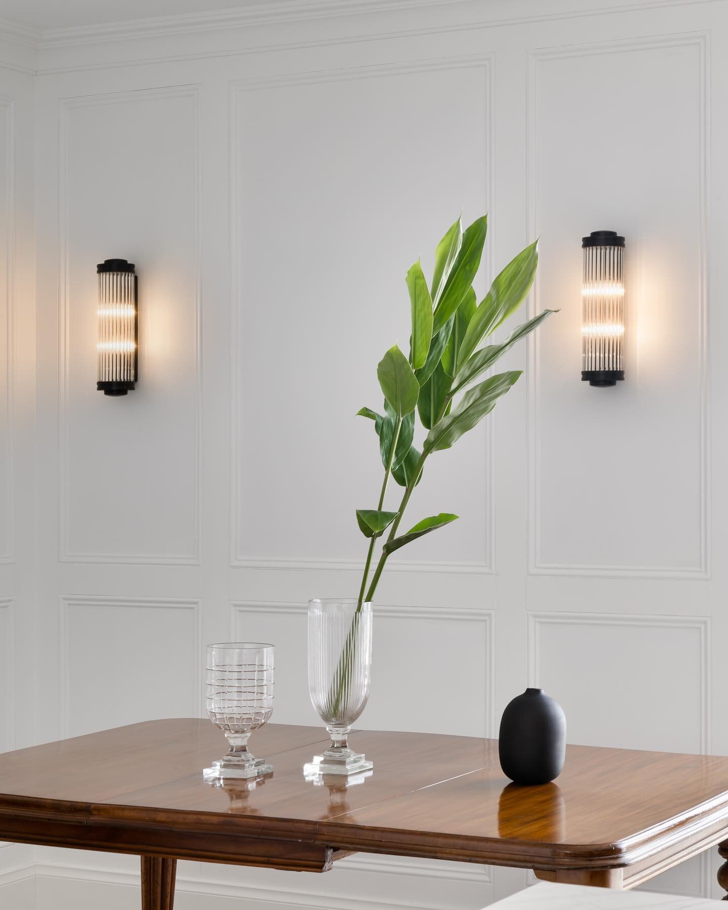 Turning a crowded corner into a tranquil dining space. 

At #RupertsResidence we used bolection mouldings on walls to create refined detailing across crisp white walls. 

The use of aged brass wall sconces from @jamessaidcollections tied in beautiful