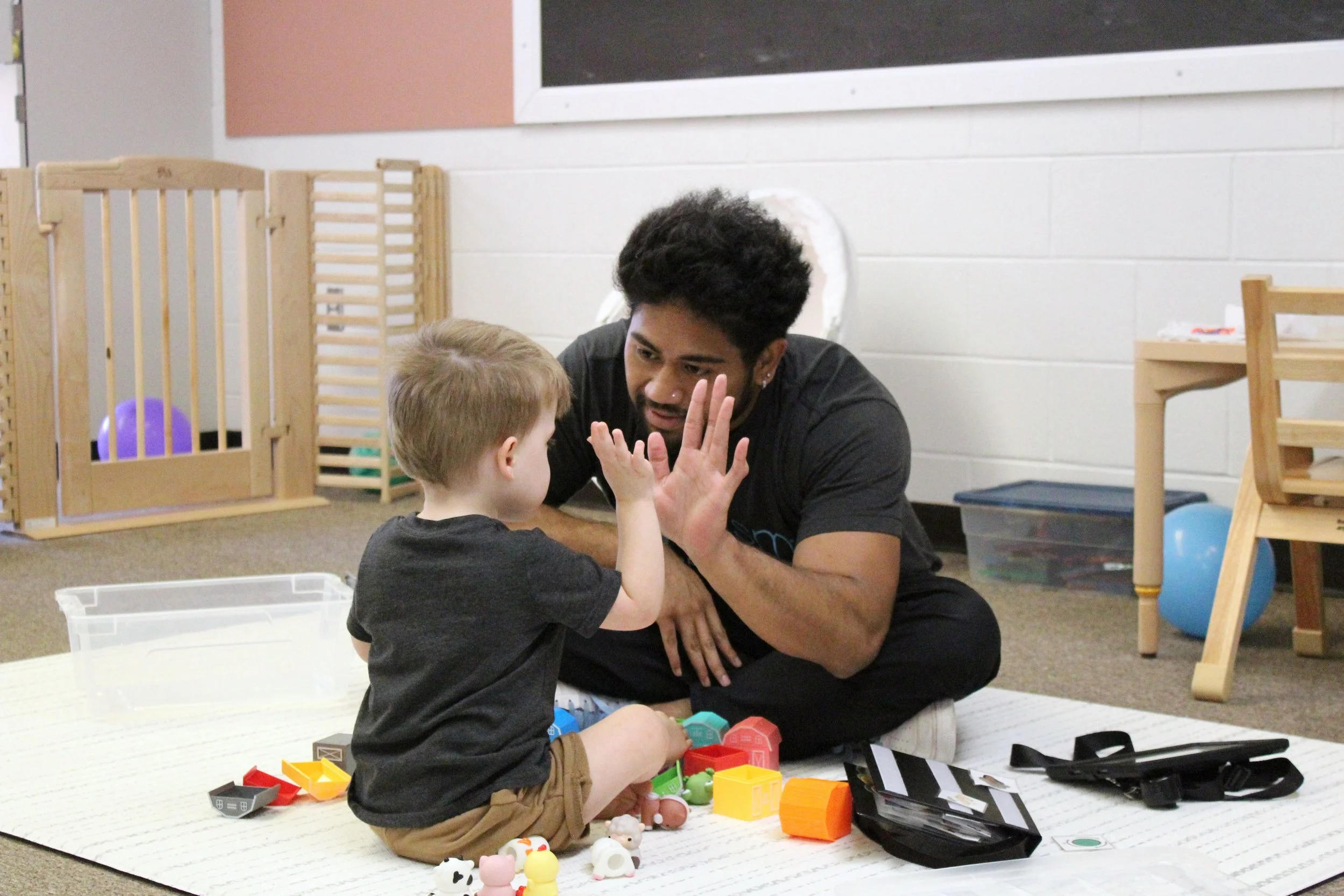 Therapist celebrating with child.