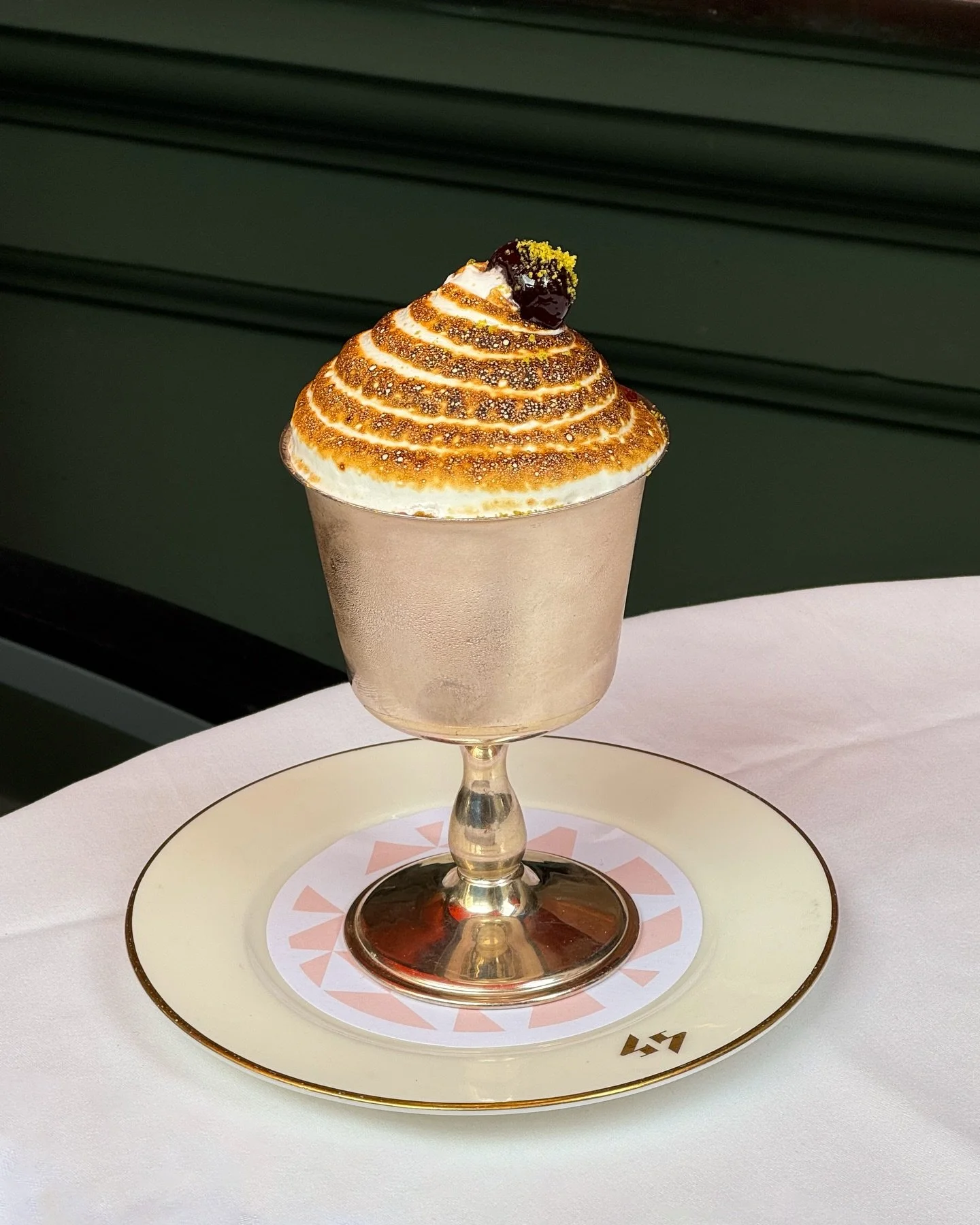 Pistachio and Cherry Baked Alaska - layers of vanilla ice cream, cherry sorbet and pistachio sponge, wrapped in Italian meringue and finished with Amarena cherries.

Book a table with us via the link in bio.