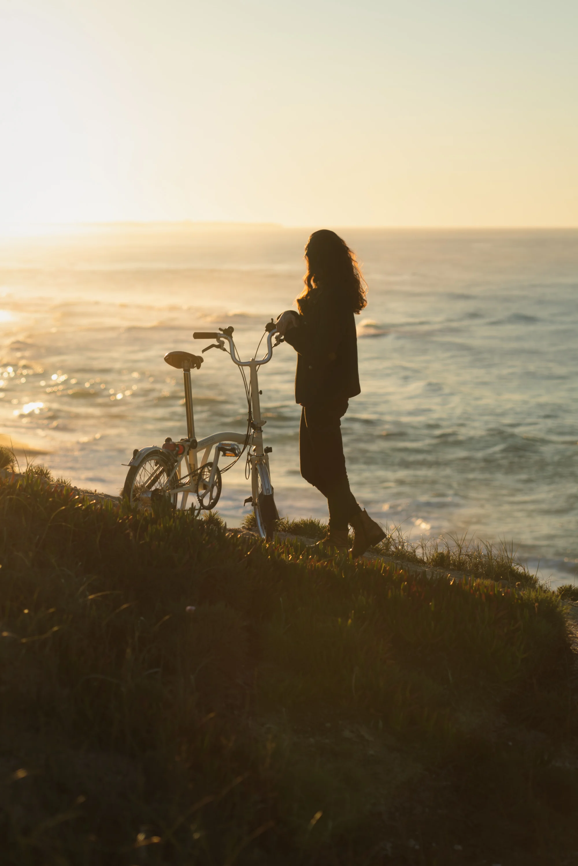 Girl at sunset with Brompton bike.