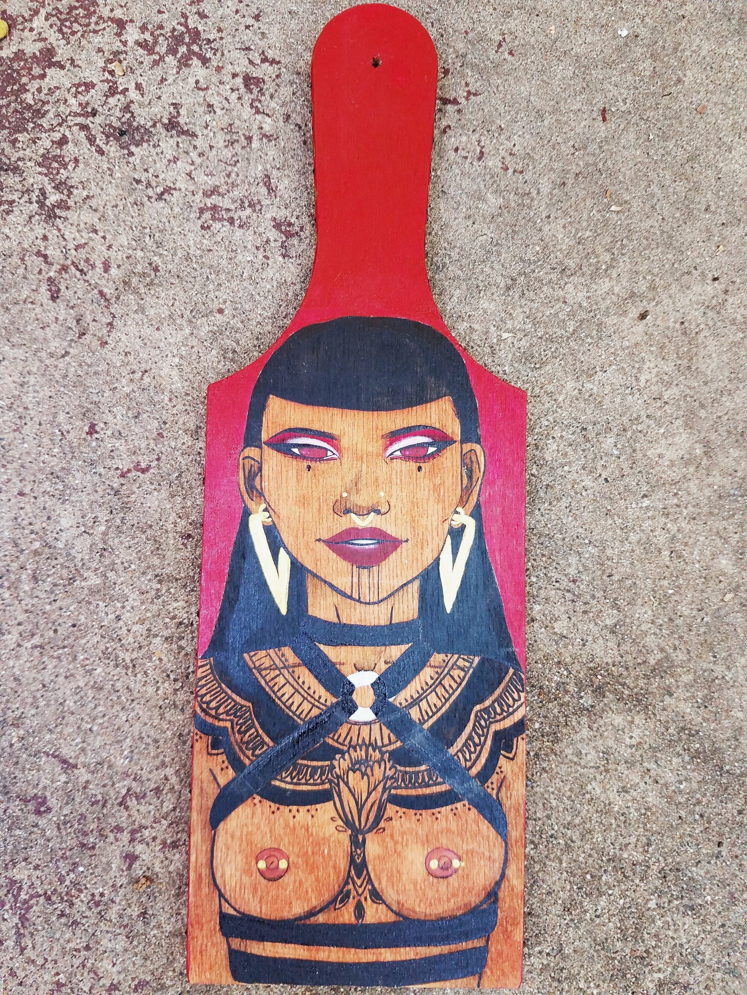  Acrylic paint and ink on wood paddle. 