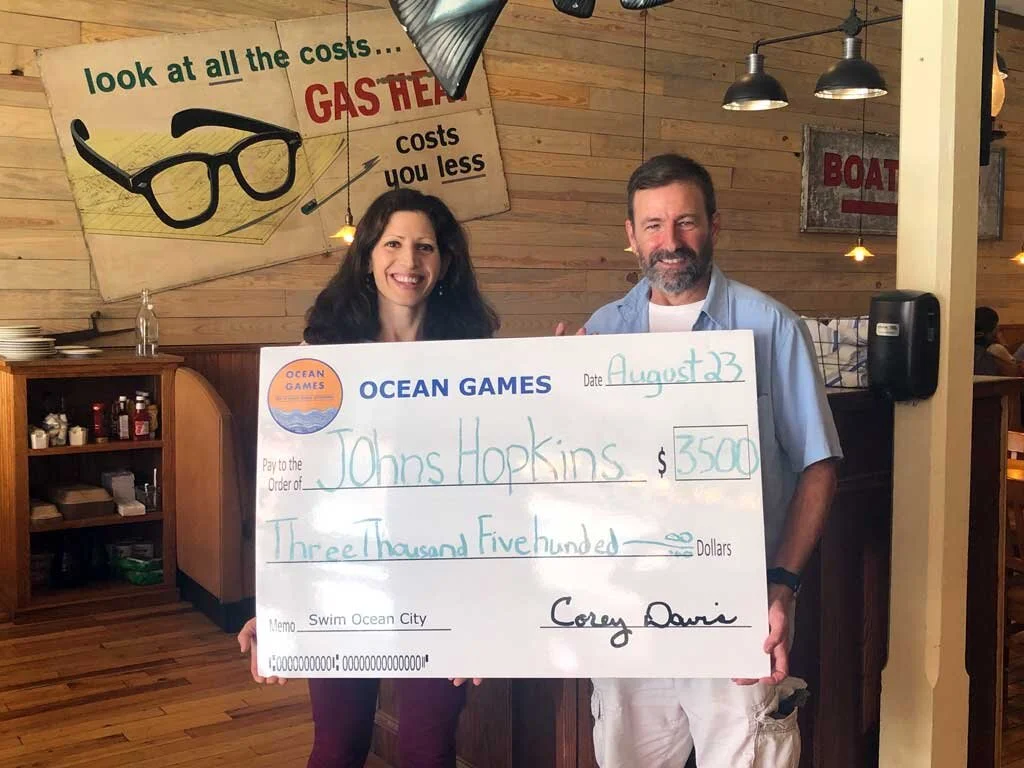 Corey Davis, President of Swim Ocean City, presents a $3,500 check to Johns Hopkins. at Boxcar on Main in downtown Berlin, MD.  (Pictured: Corey Davis, Dr. Kate Bechtold of Johns Hopkins)