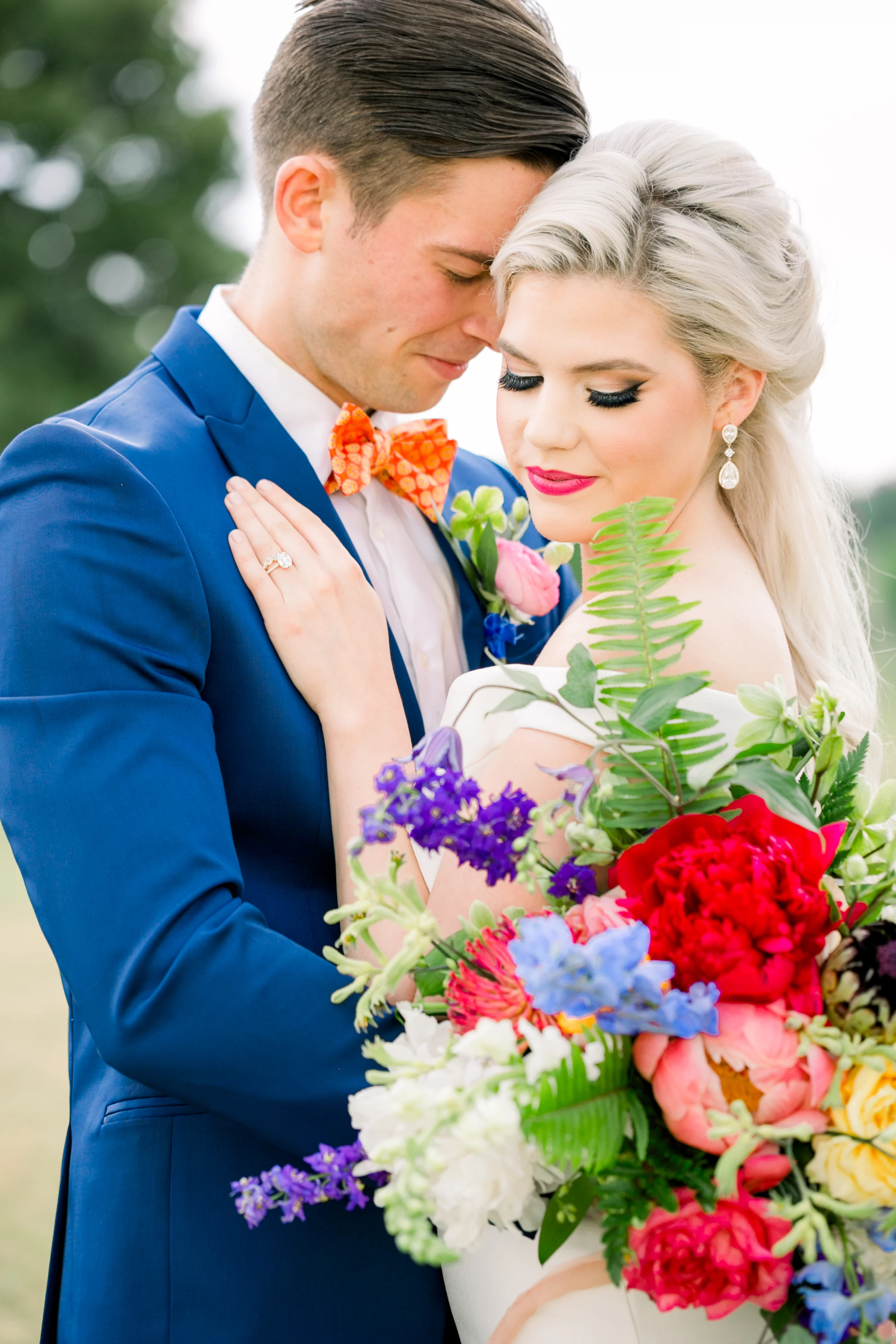 Bride and groom outside with bright floral bouquet