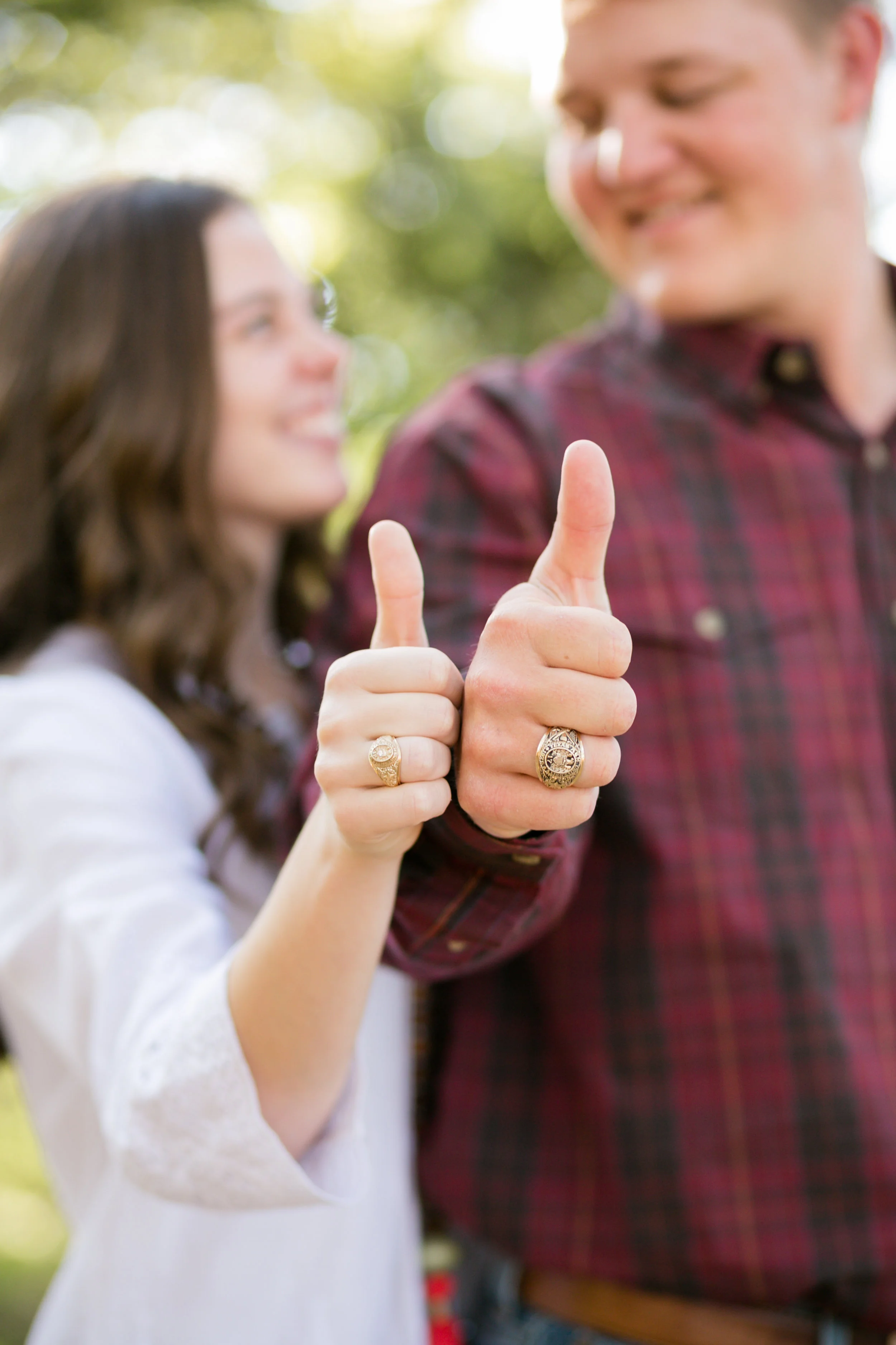Couple thumbs up with class rings