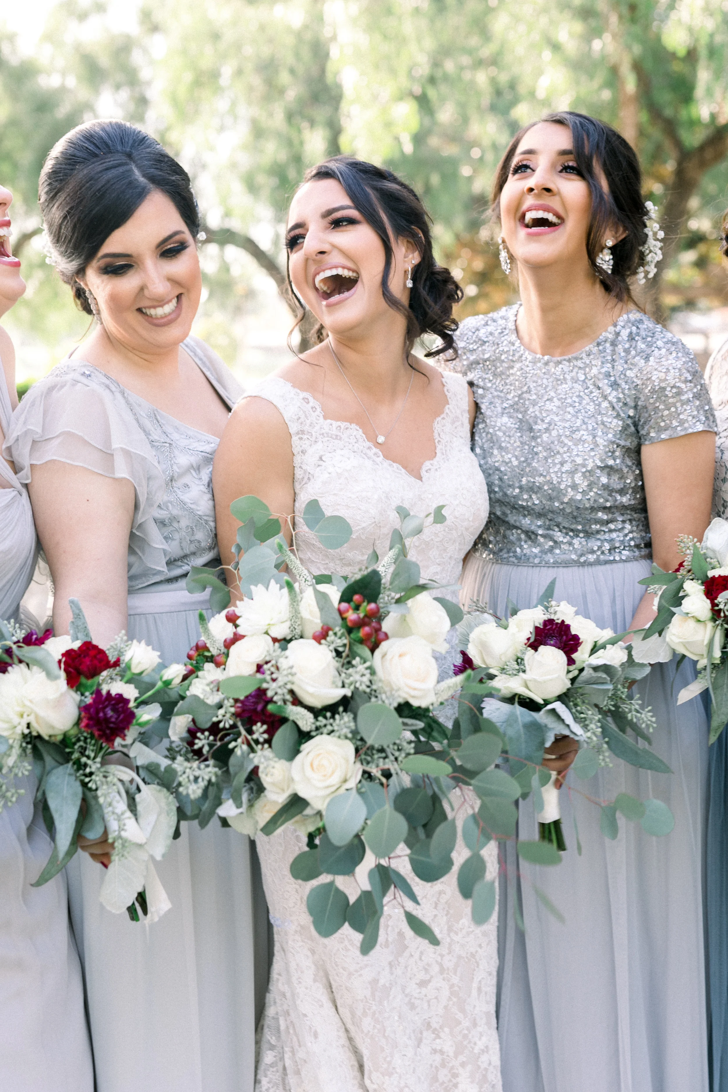 Bride laughs with her bridesmaids in grey