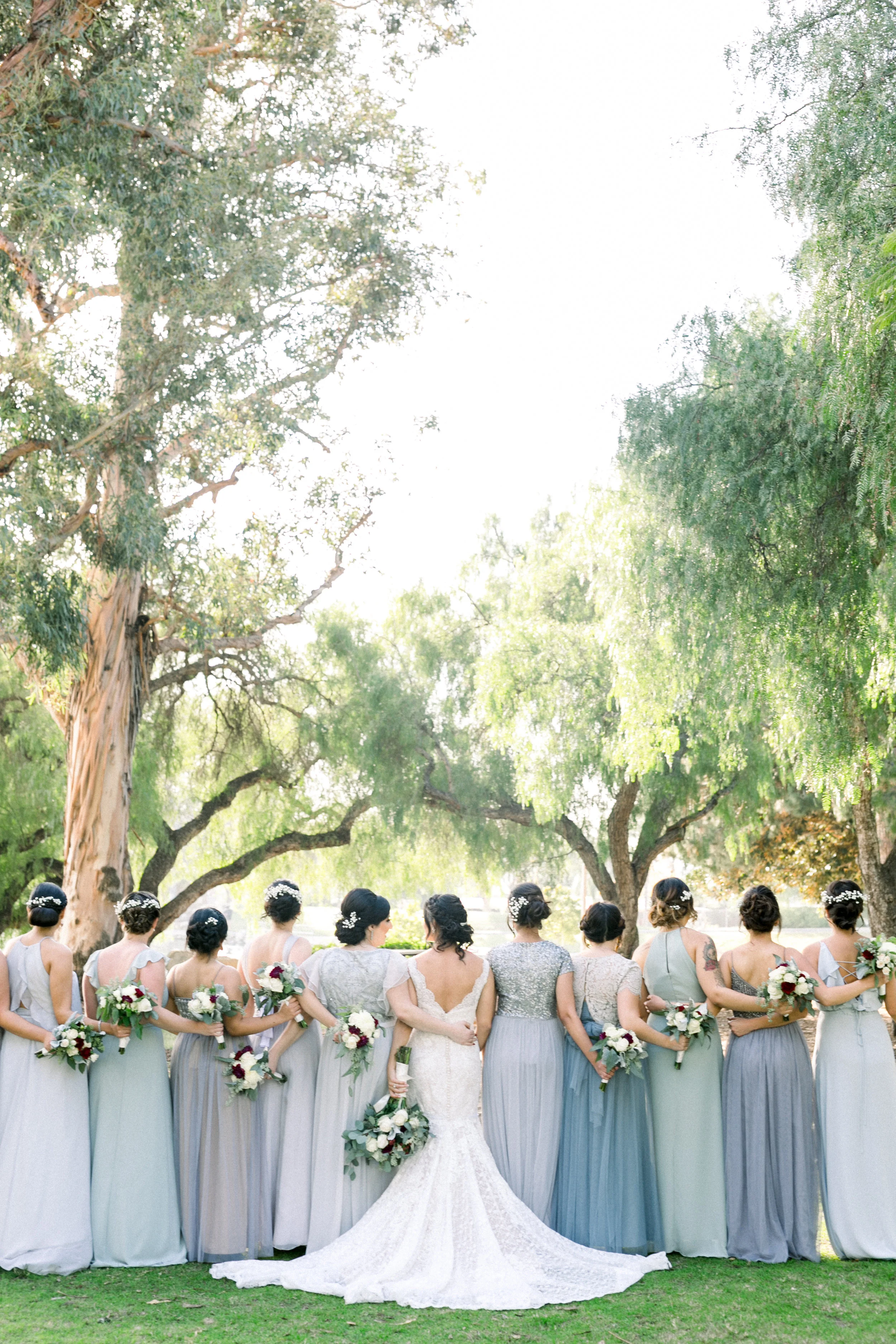 Bride and bridesmaids in grey dresses outside