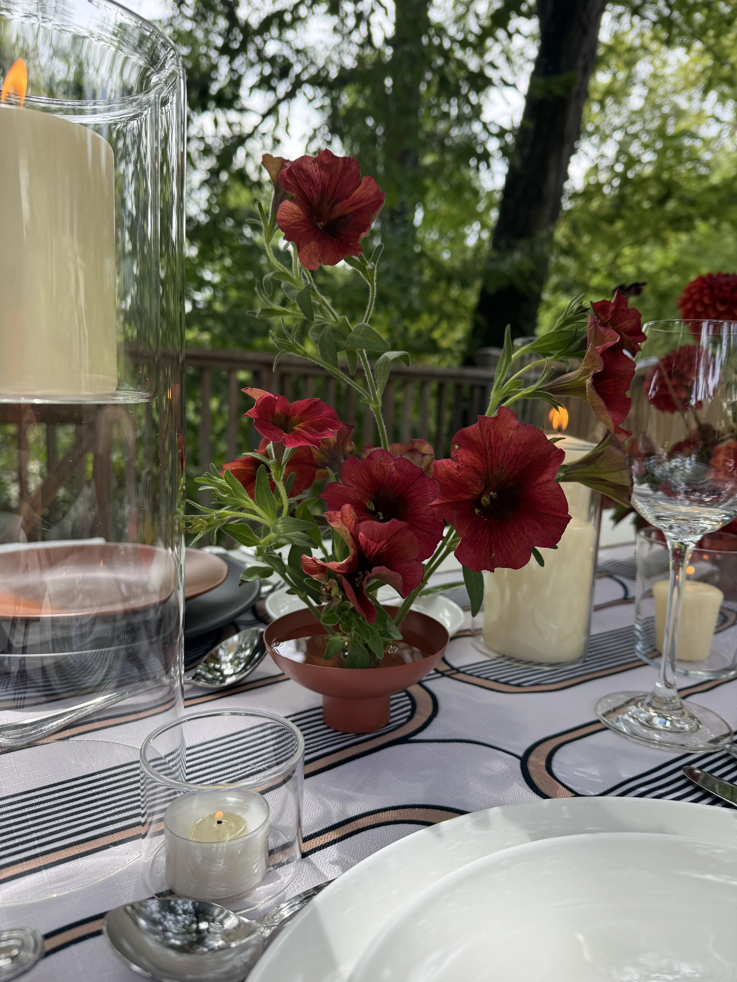 Wedding tablescape detail featuring red petunias, pillar candles, and glassware at The Madrona Healdsburg mockup with Caitlin Gutierrez Events.JPG
