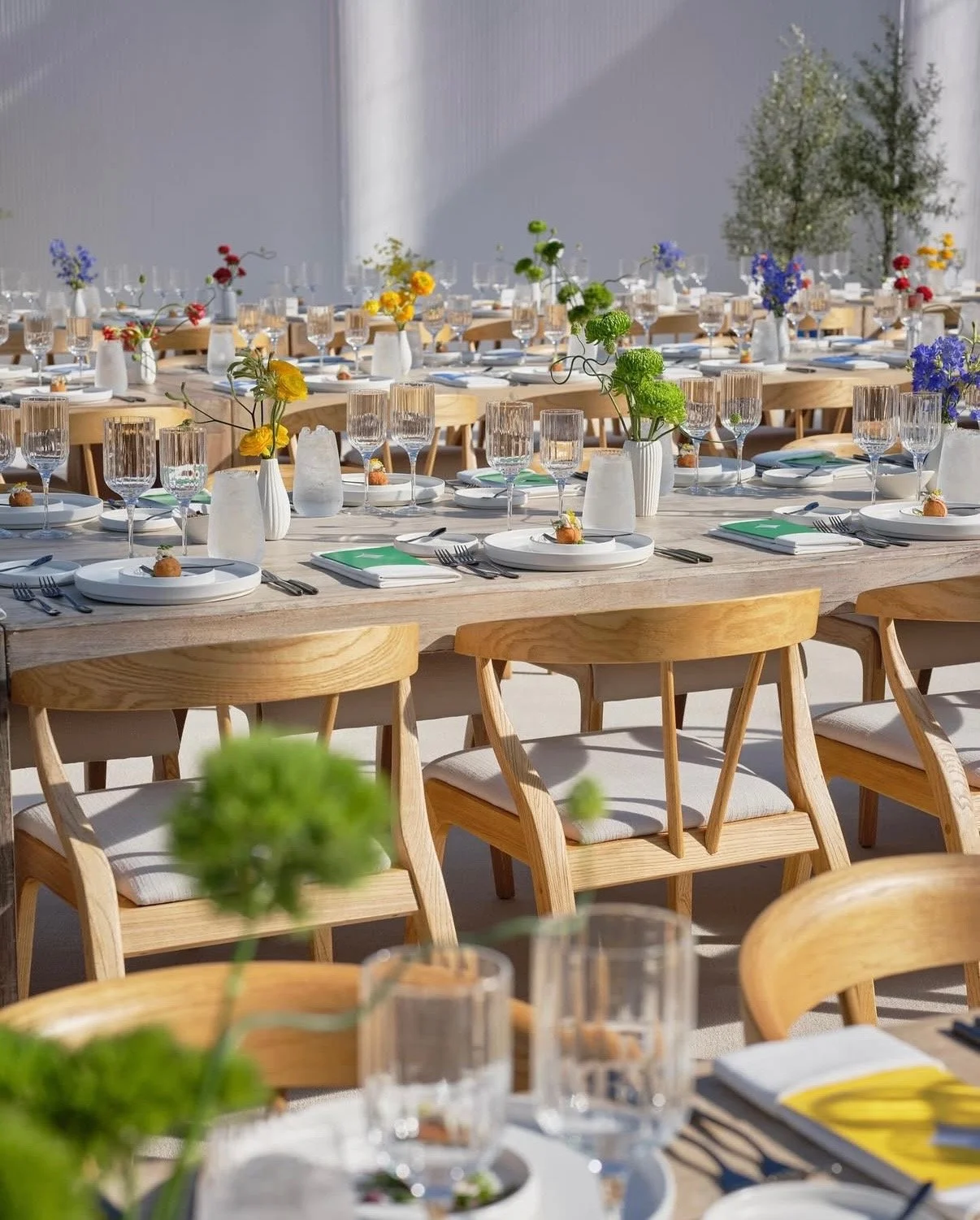 A corporate brand keynote event featuring on-brand table designs and modern, colorful flower arrangements.