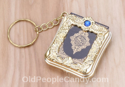 A Holy Koran key chain inside a book case