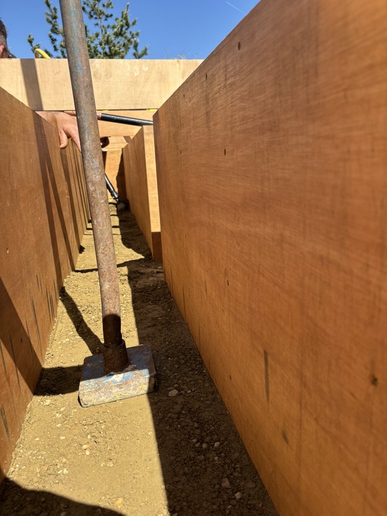 Rammed earth being compacted in form work