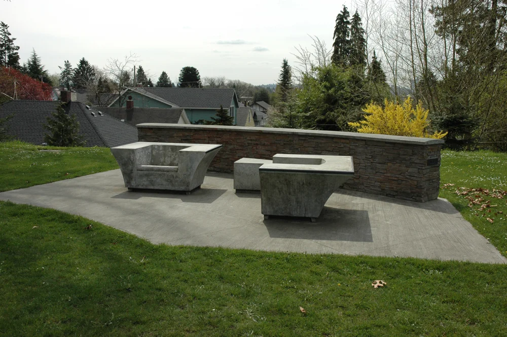 Concrete armchairs with bronze trim.