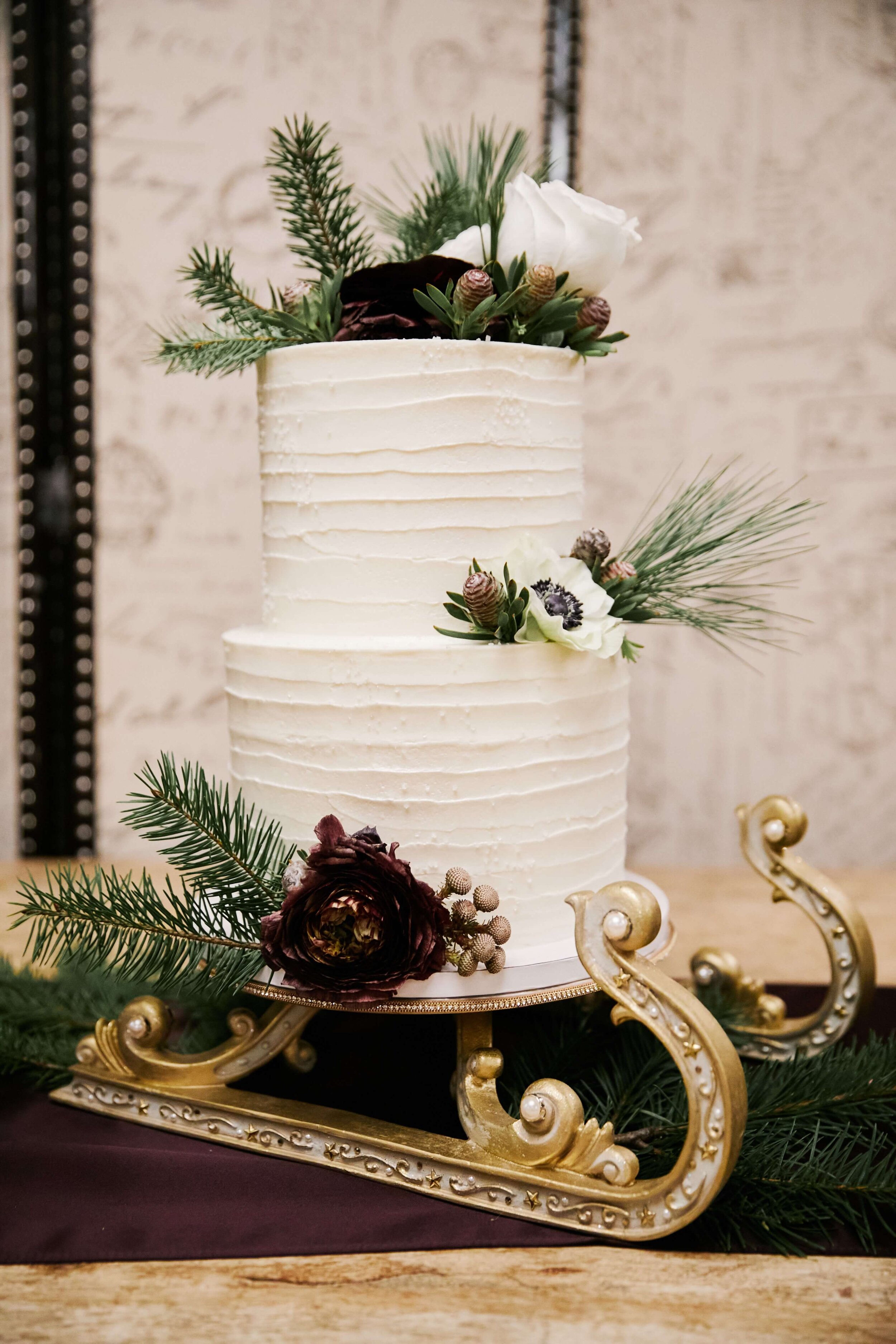 Christmas themed wedding cake on gold sleigh