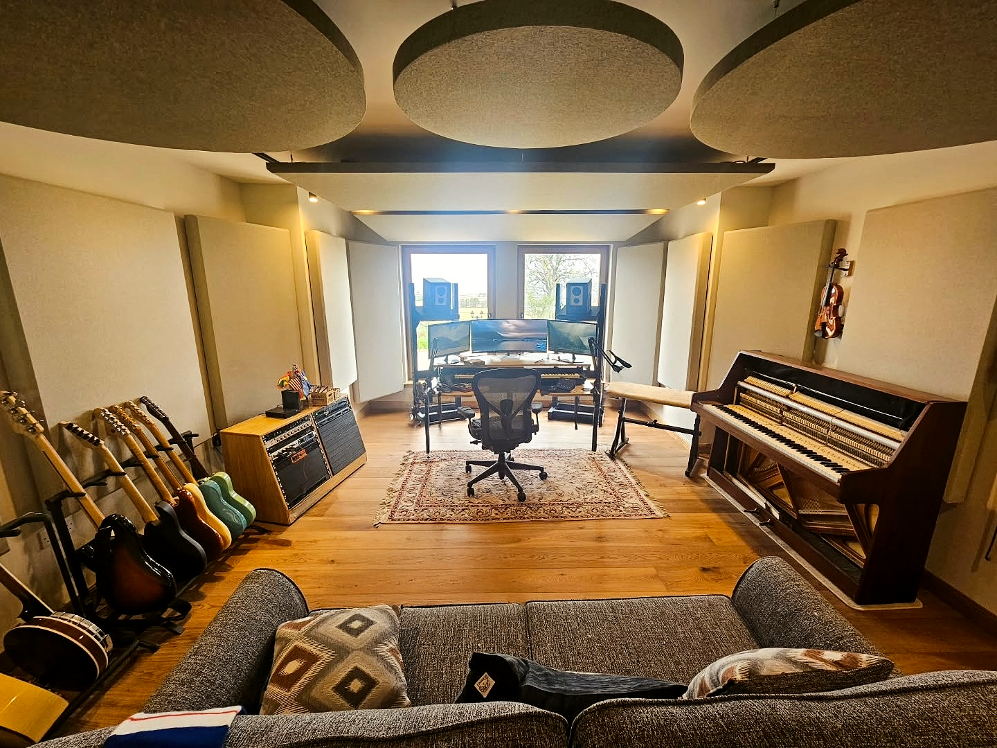  Home recording studio with guitars, upright piano and Barefoot speakers. The mix position looks out over open countryside.  