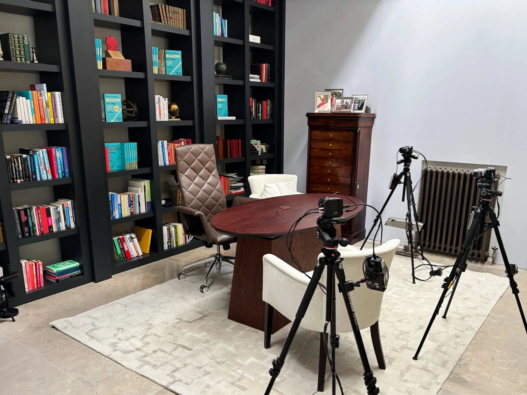  Newsdesk style podcast studio with cameras and bookshelves 