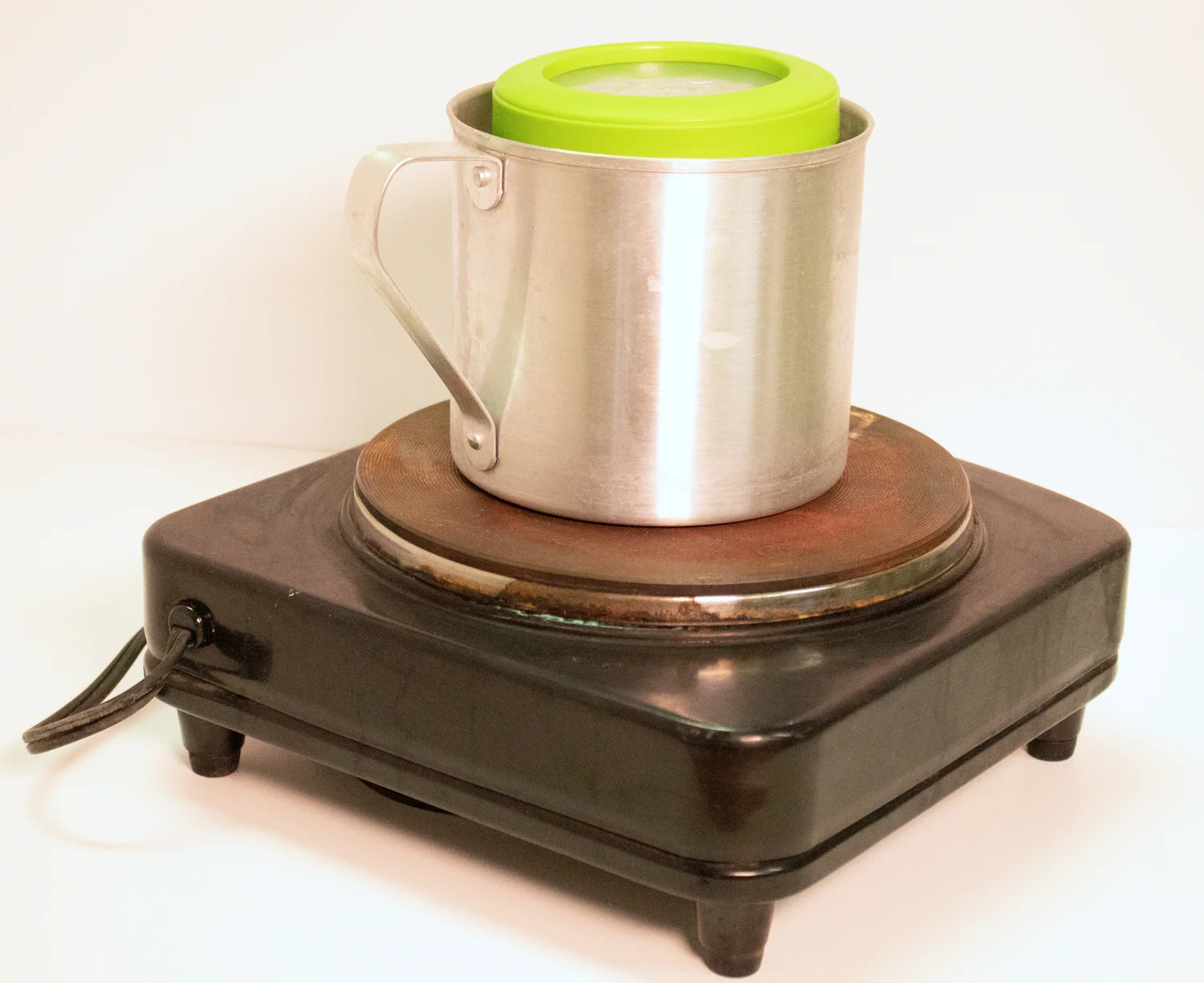 Side view of double boiler made with metal container, plastic container and hot plate.