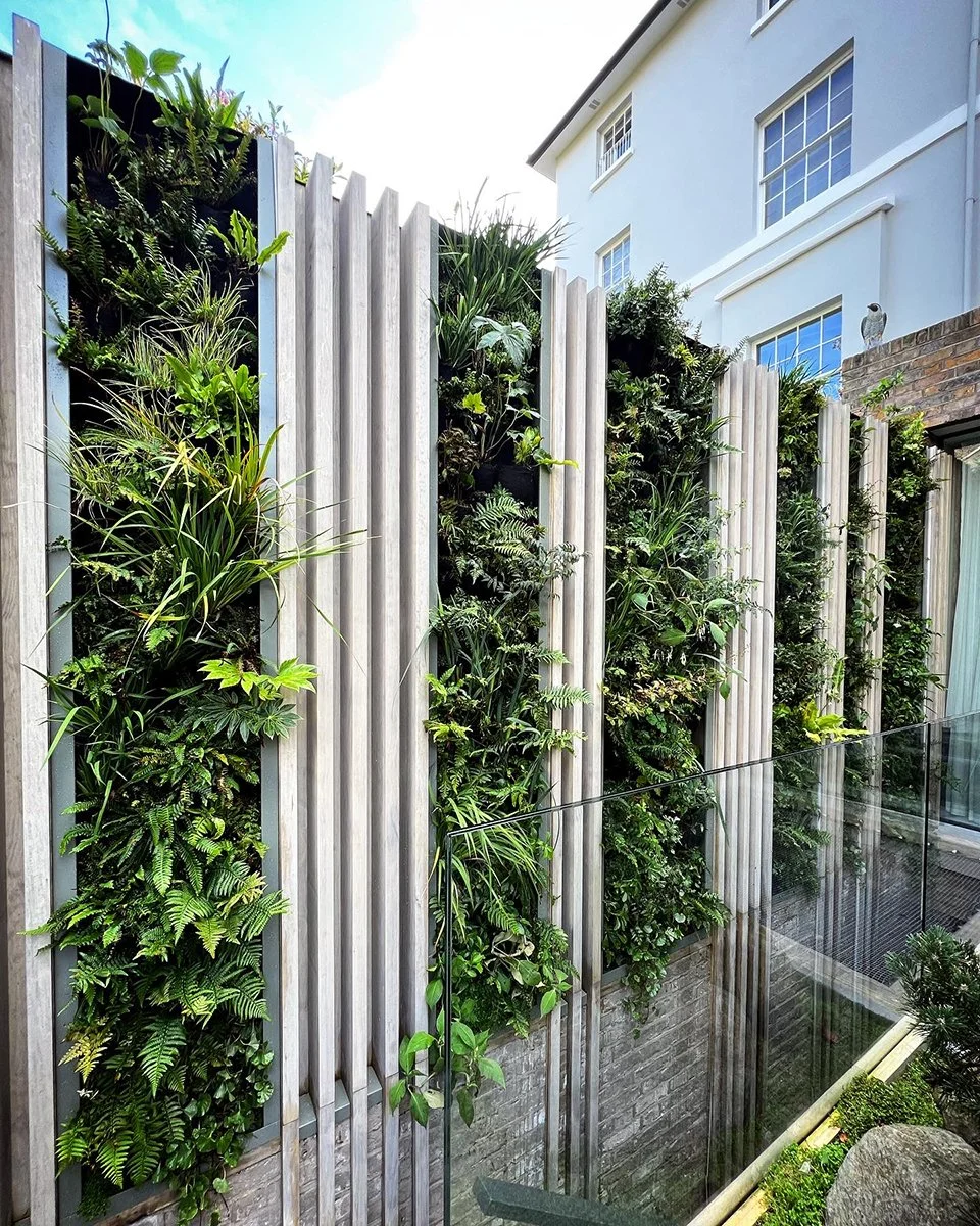 Expansive vertical garden covering a large outdoor wall with diverse greenery enhancing urban environment