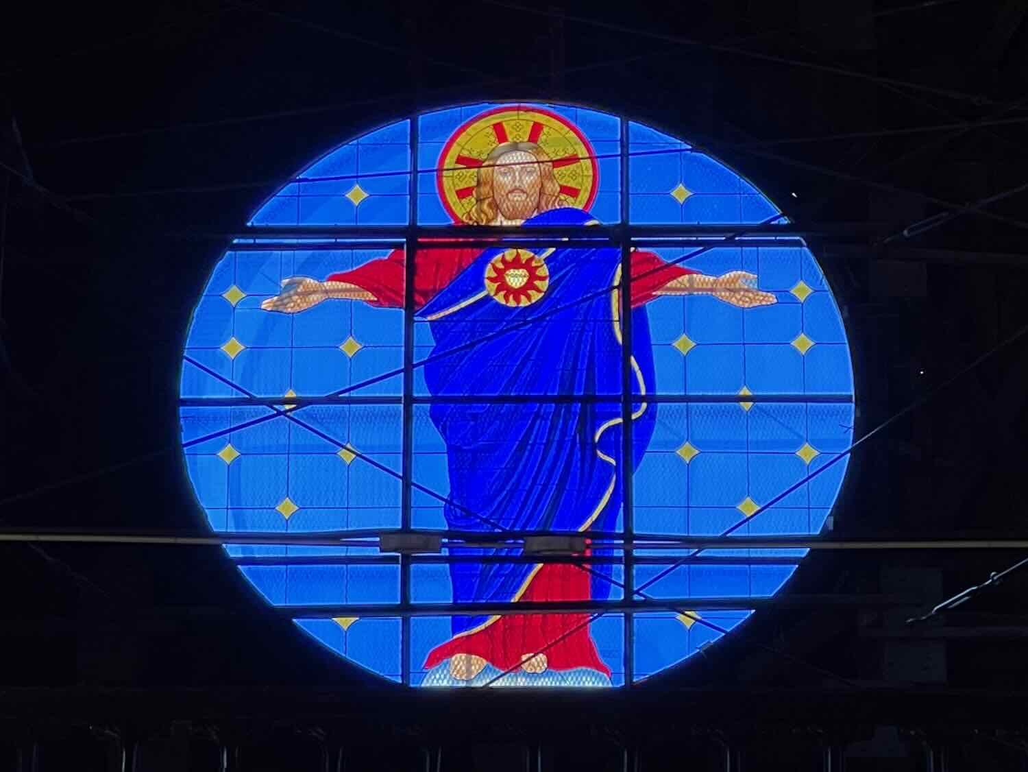 The large, brightly-colored, stained glass window over the entrance reflected the theme of Jesus's sacred heart