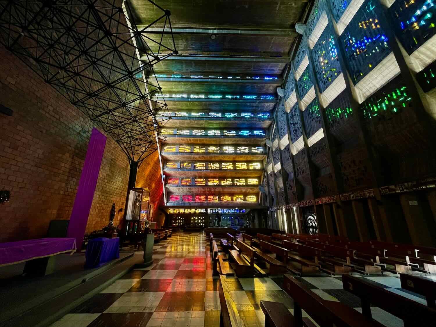 Sunlight shines through the stained glass in the terraced roof of the El Rosario Church in a dappled rainbow