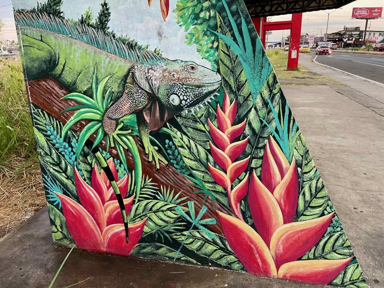 A green iguana among heliconia flowers