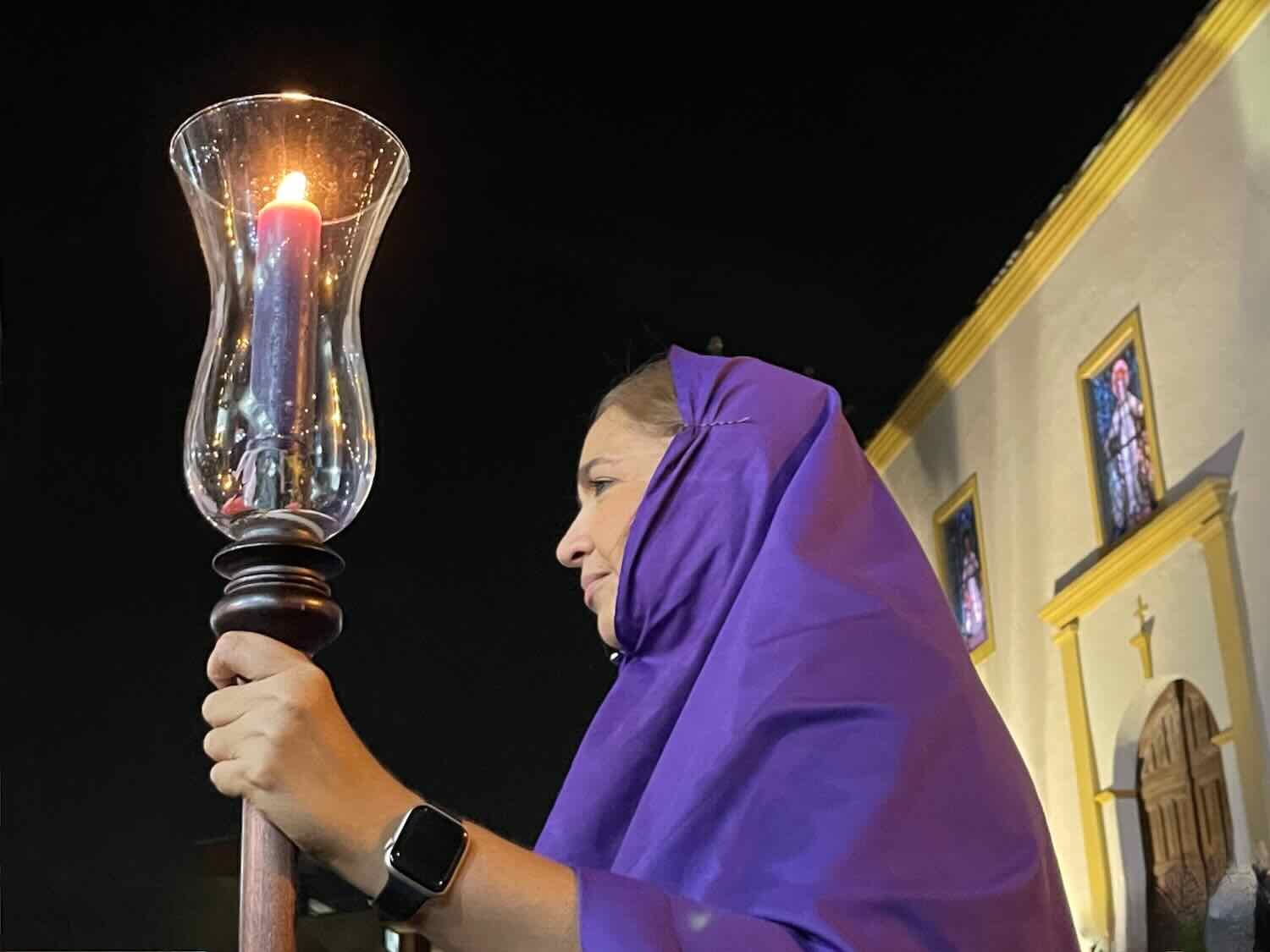 Acolytes in purple robes carried candles to light the way