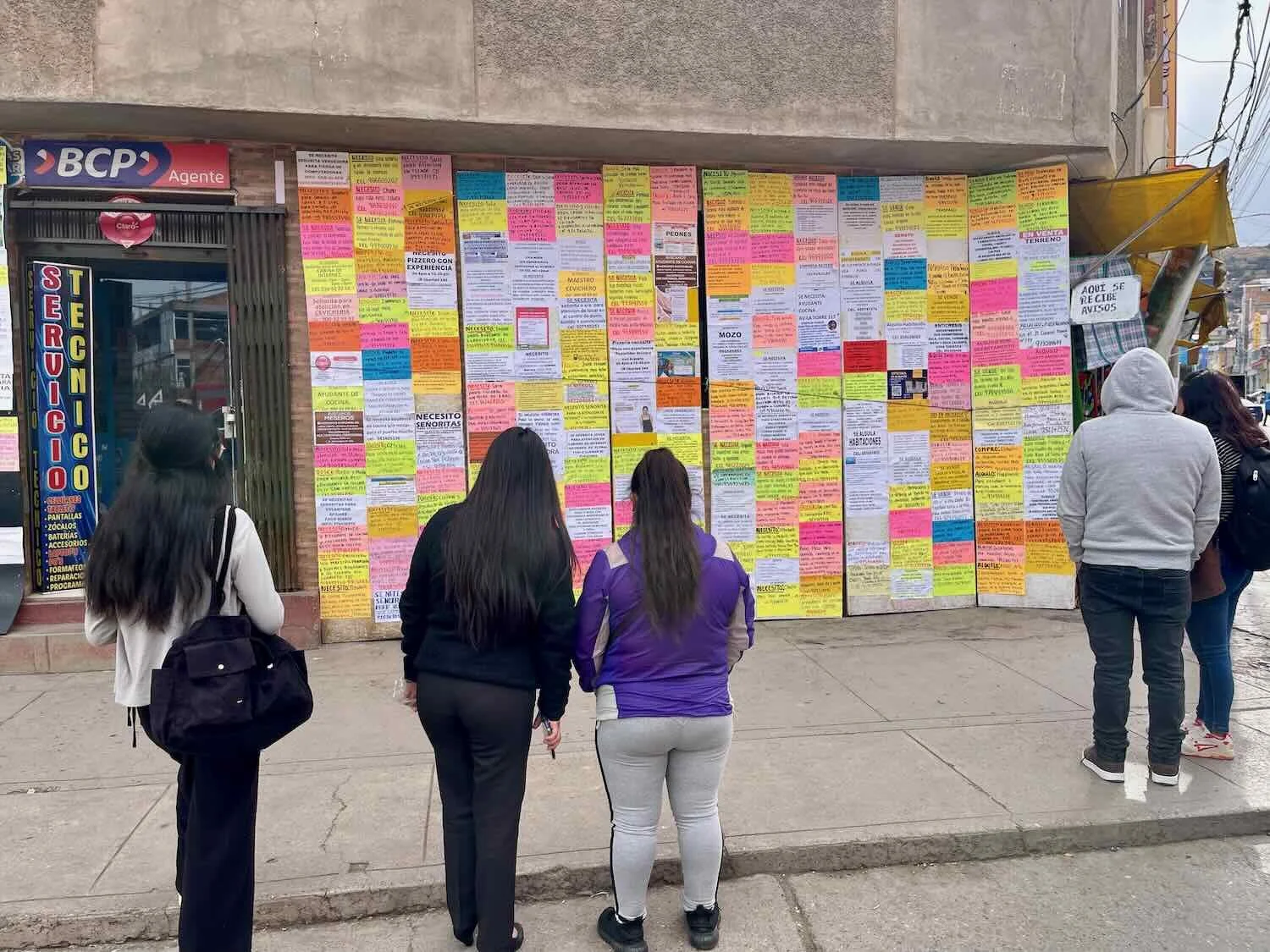 People on the street perused the 'classified ads' - hand-written notices of jobs and items for sale, posted outside a bank.