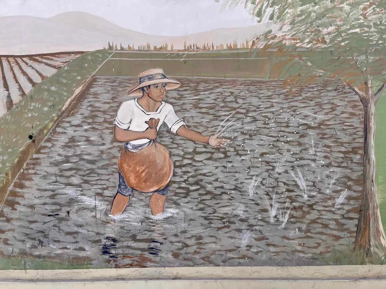 Mural of farmer planting rice seeds