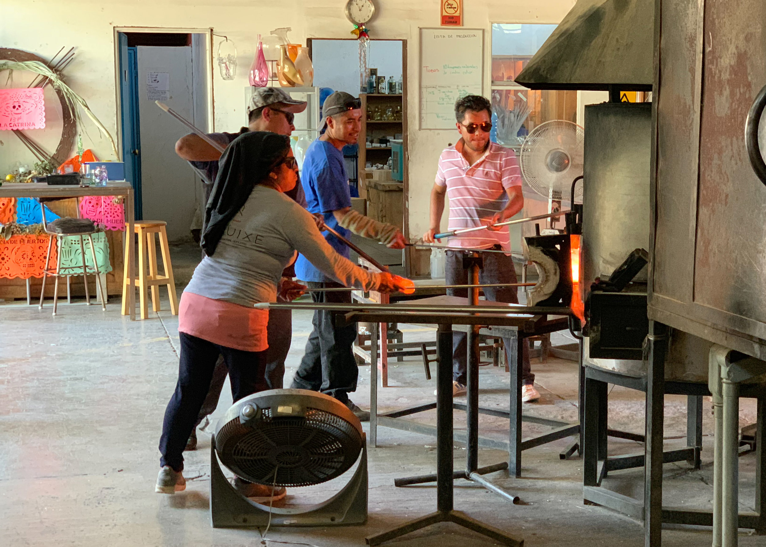 A group of artisans blowing glass.