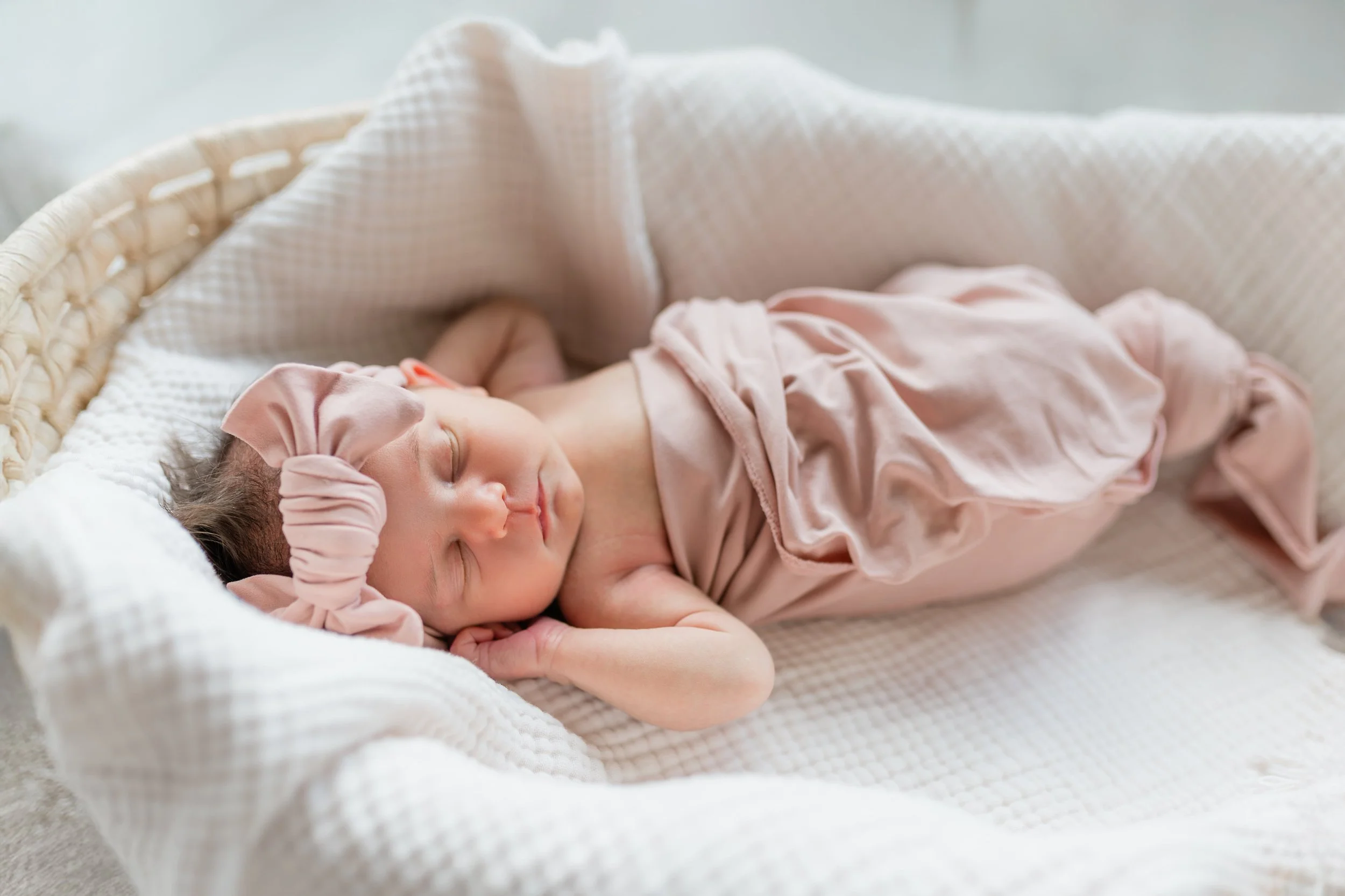 Newborn baby girl sleeping in a basket