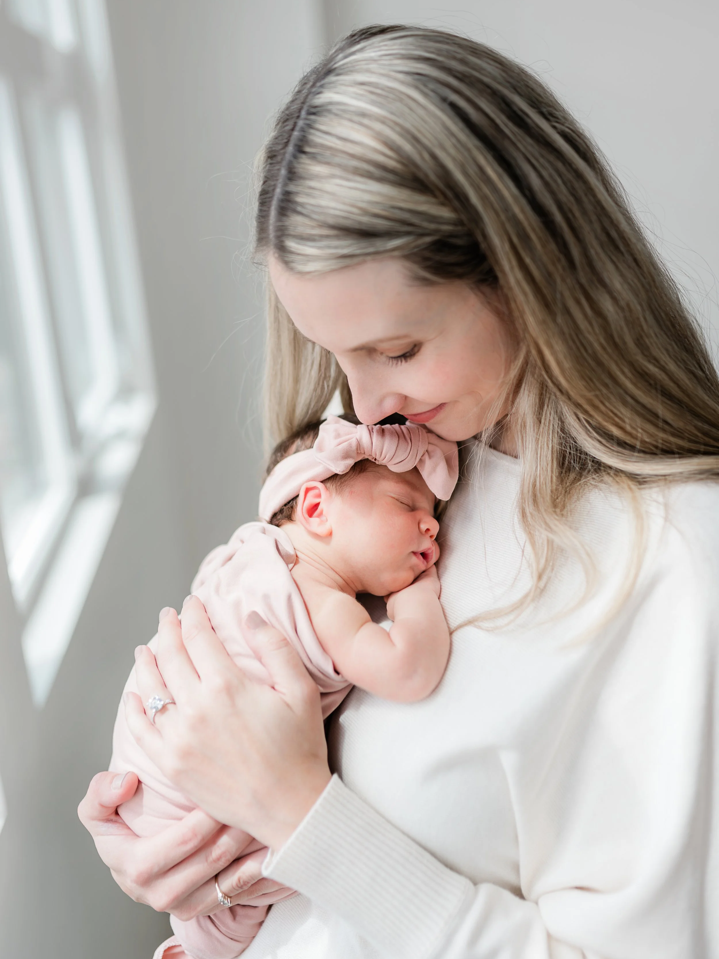 mom holding newborn baby girl in portland studio