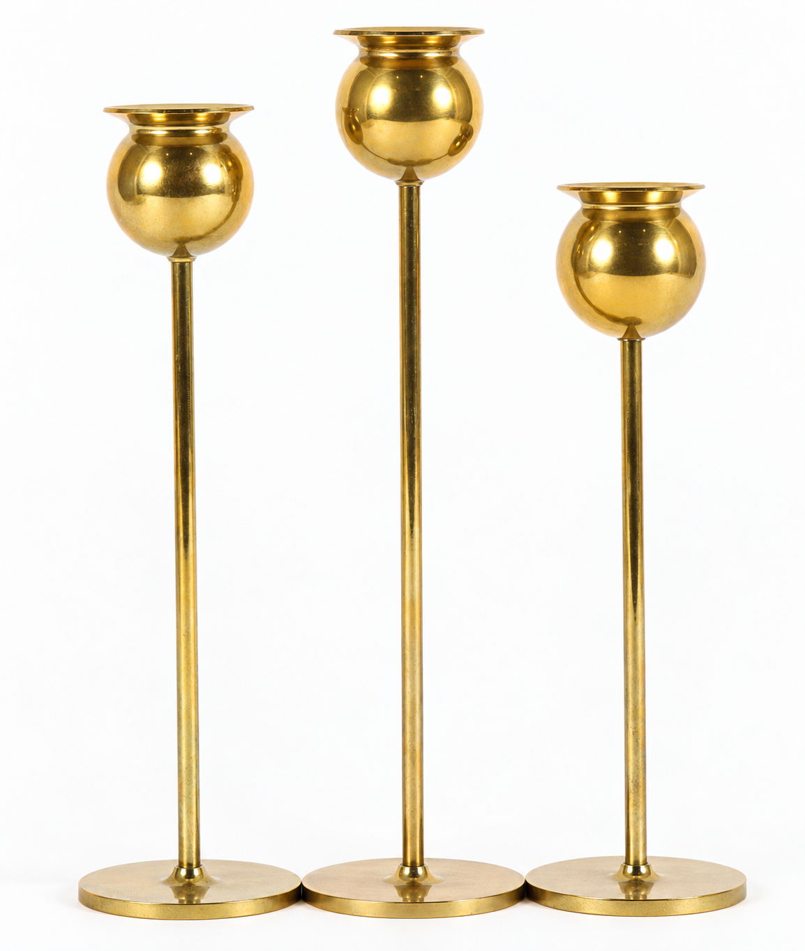 Three Brass Candlesticks on White.png