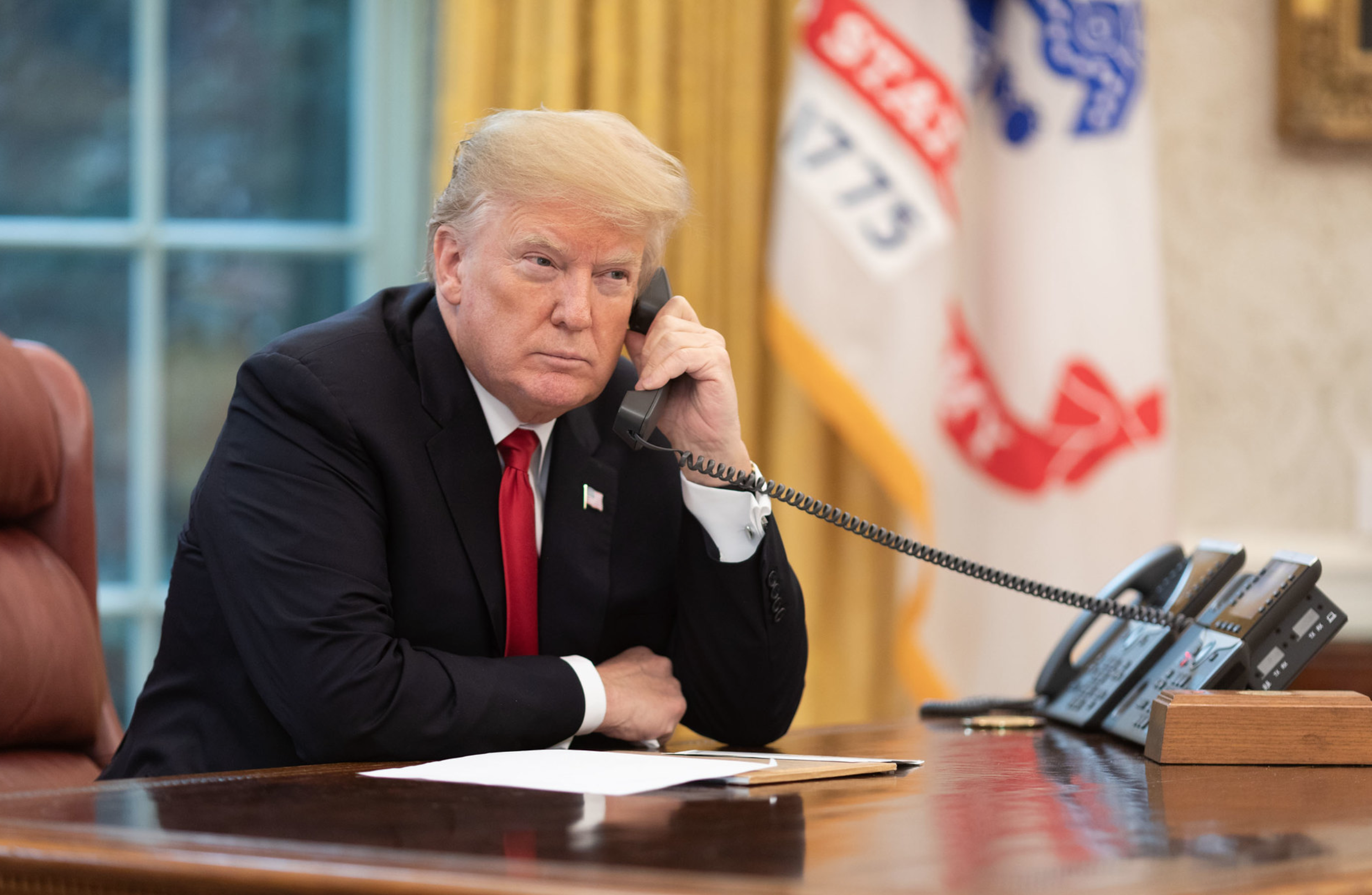 President Donald Trump talks on the telephone at the White House. White House
