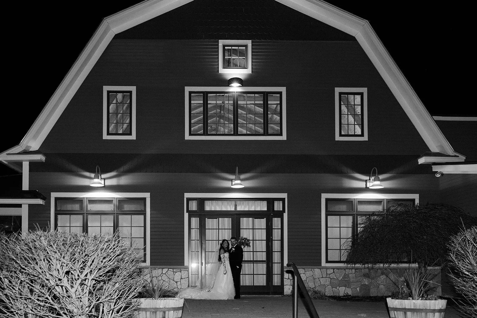 A bride and groom in front of their barn Maine Wedding venue