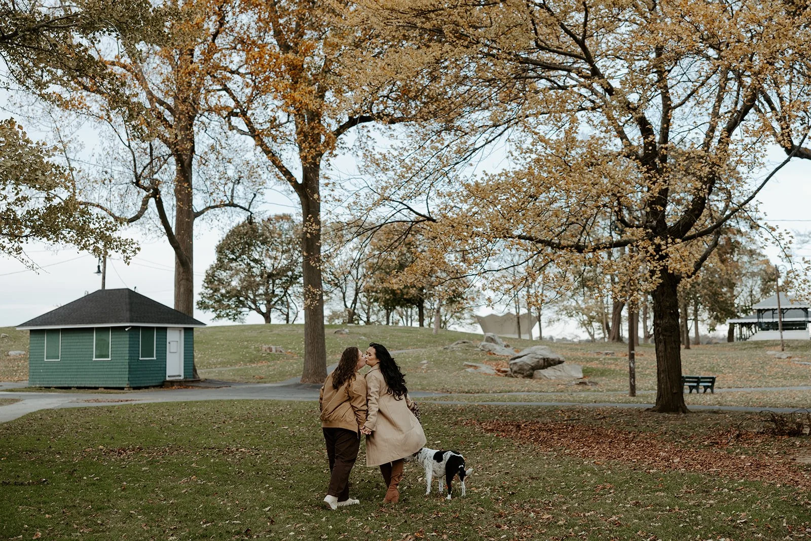 A couple kissing while walking away from the camera for their Salem Willow engagement photos
