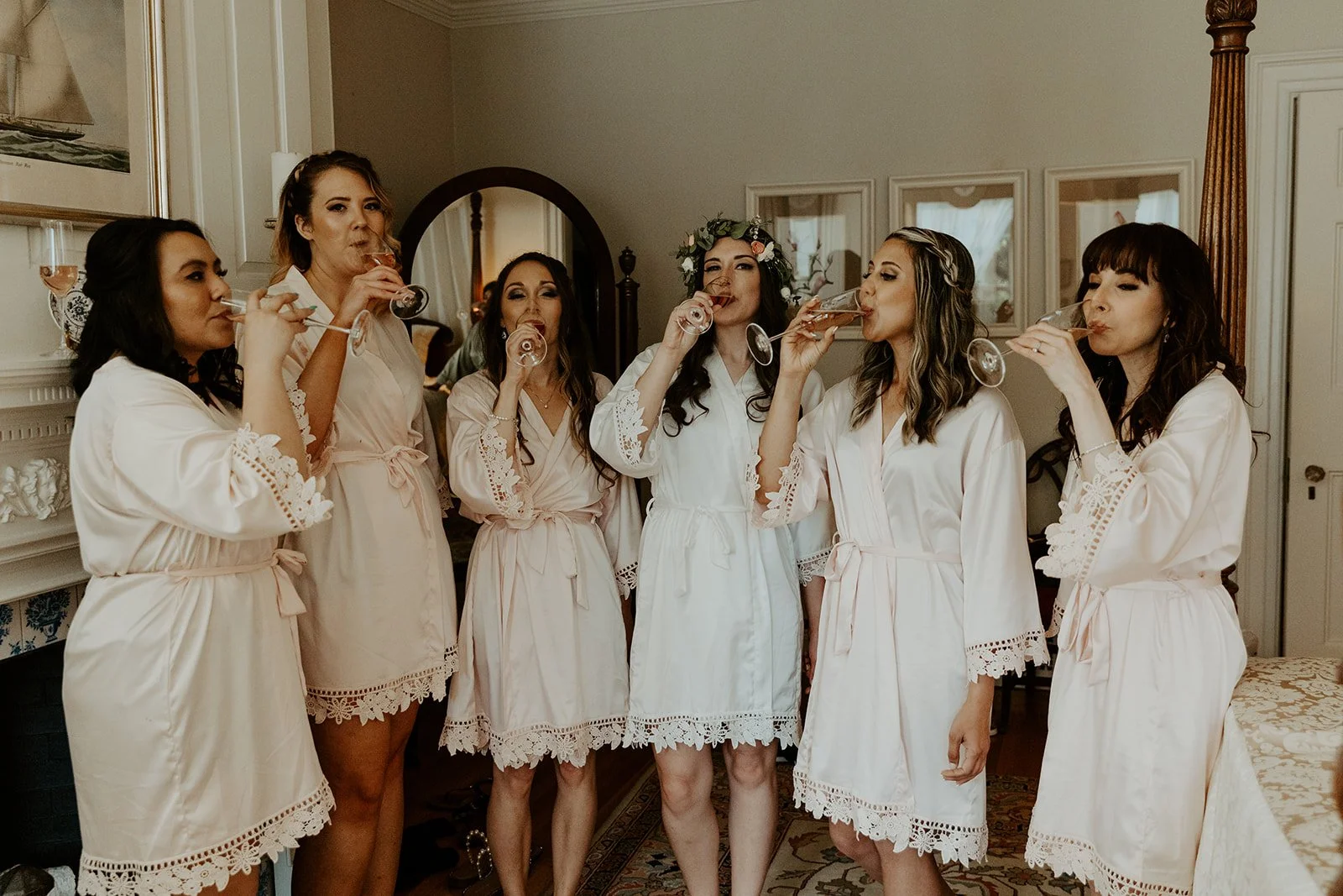 A bride and her bridesmaids getting ready for a wedding, drinking champagne