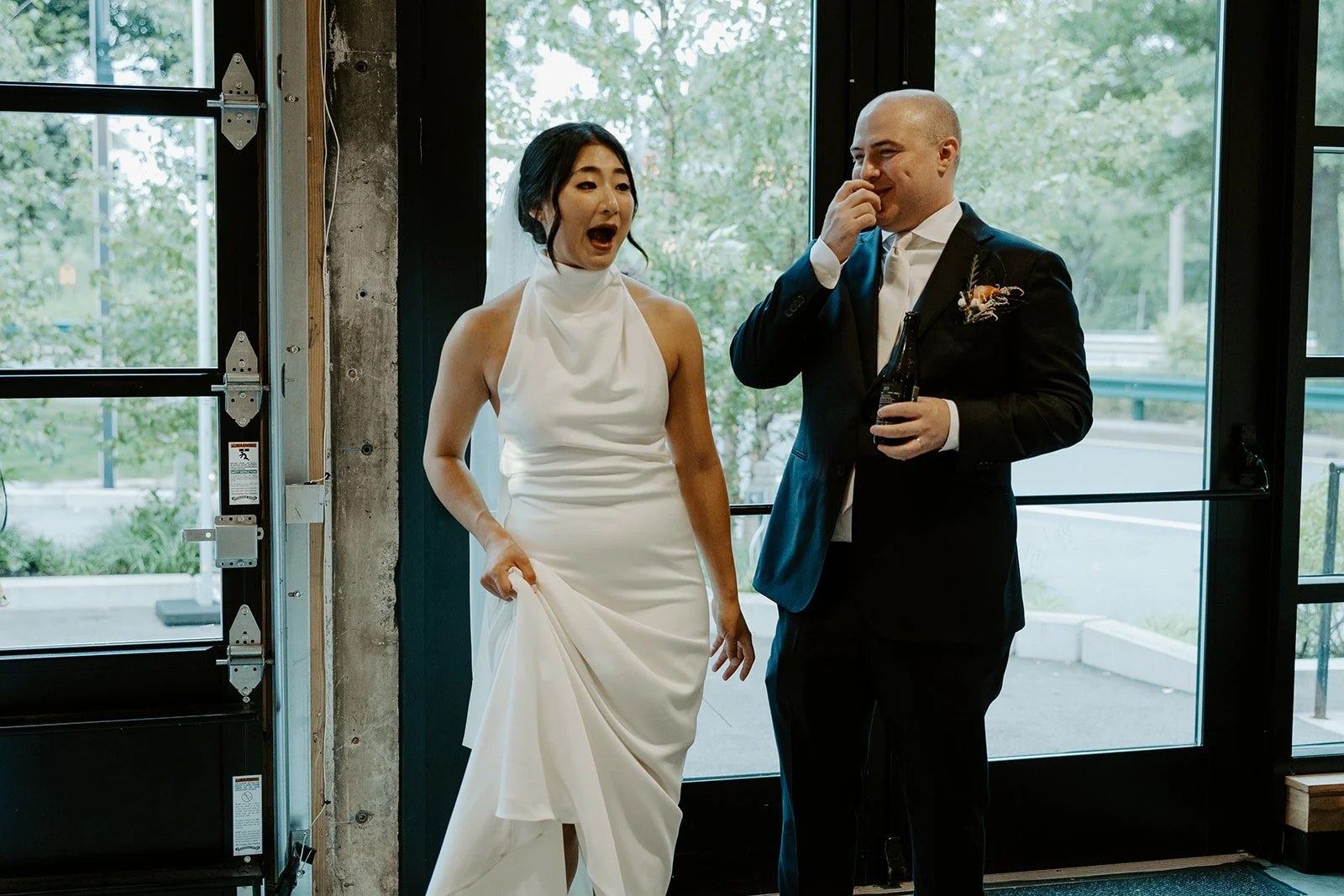 A candid photo of a bride and groom seeing their wedding reception setup for the first time