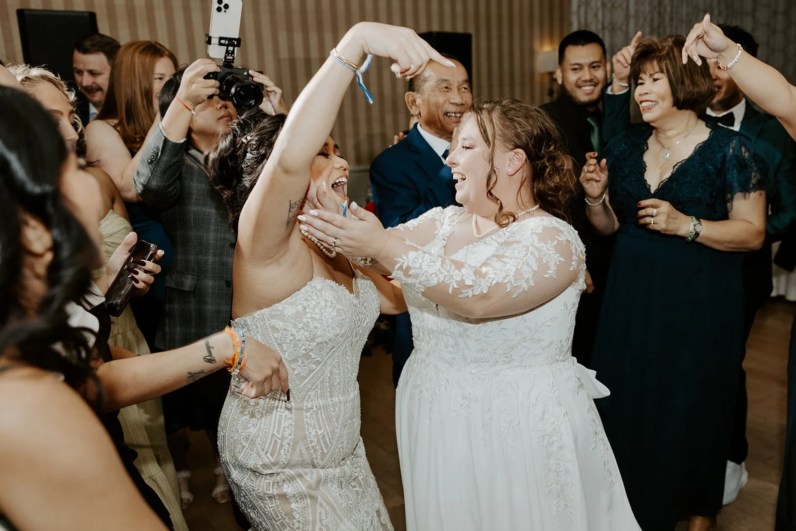 Two brides dancing at their wedding reception after finishing their wedding planning checklist