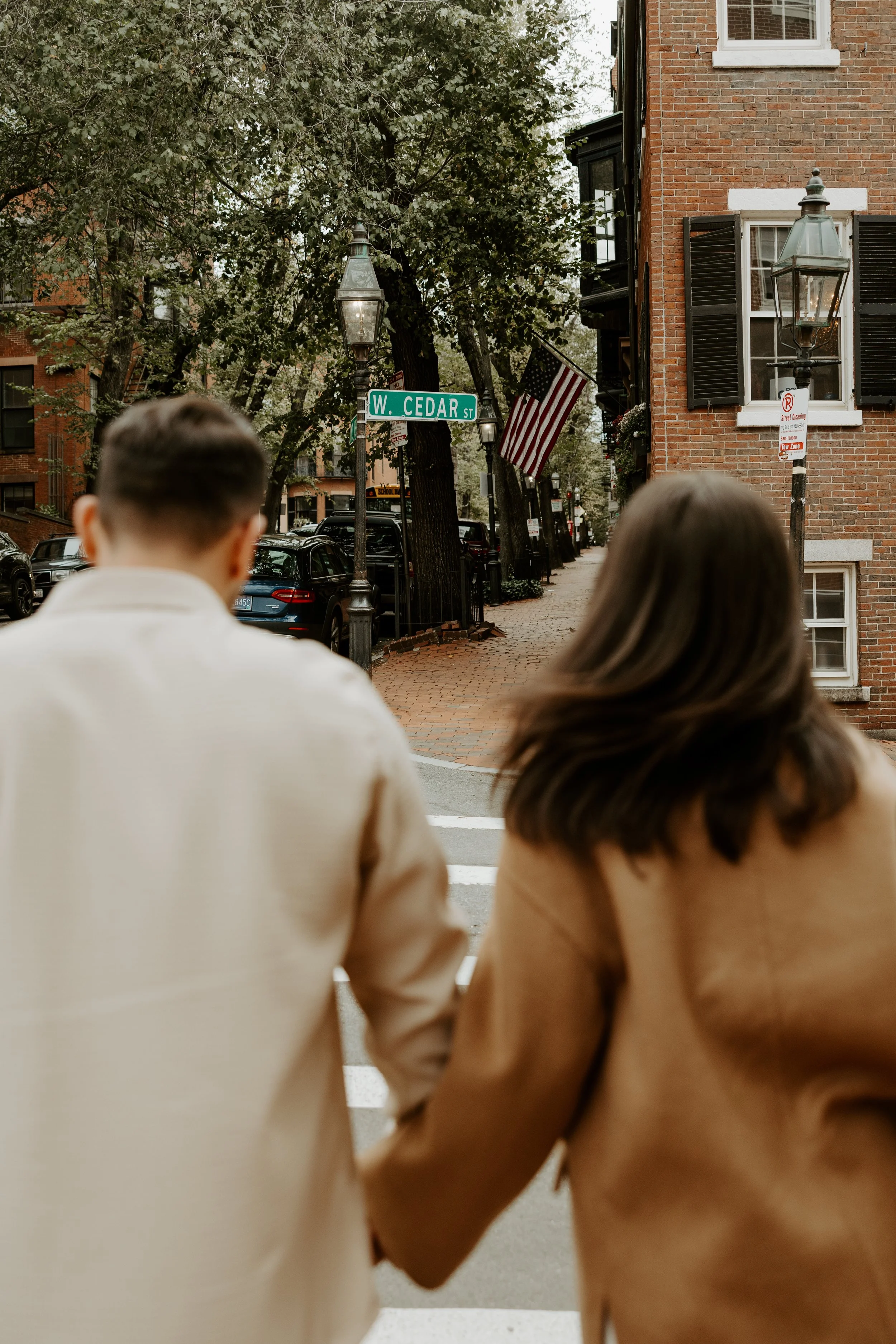 A couple crossing the street in Beacon Hill, captured by a Boston engagement photographer