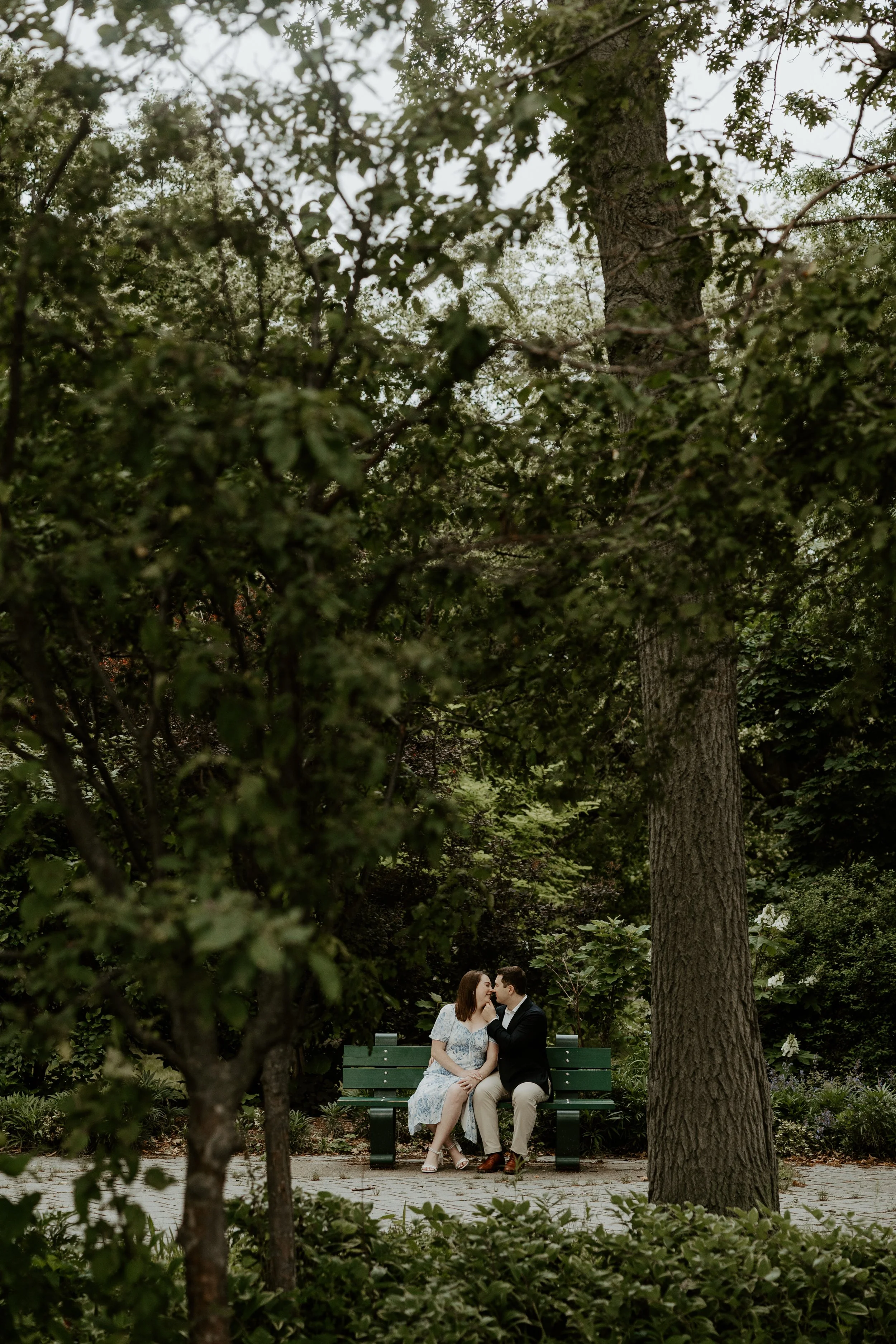 A couple sitting on a bench at The Esplanade for their engagement photsohoot