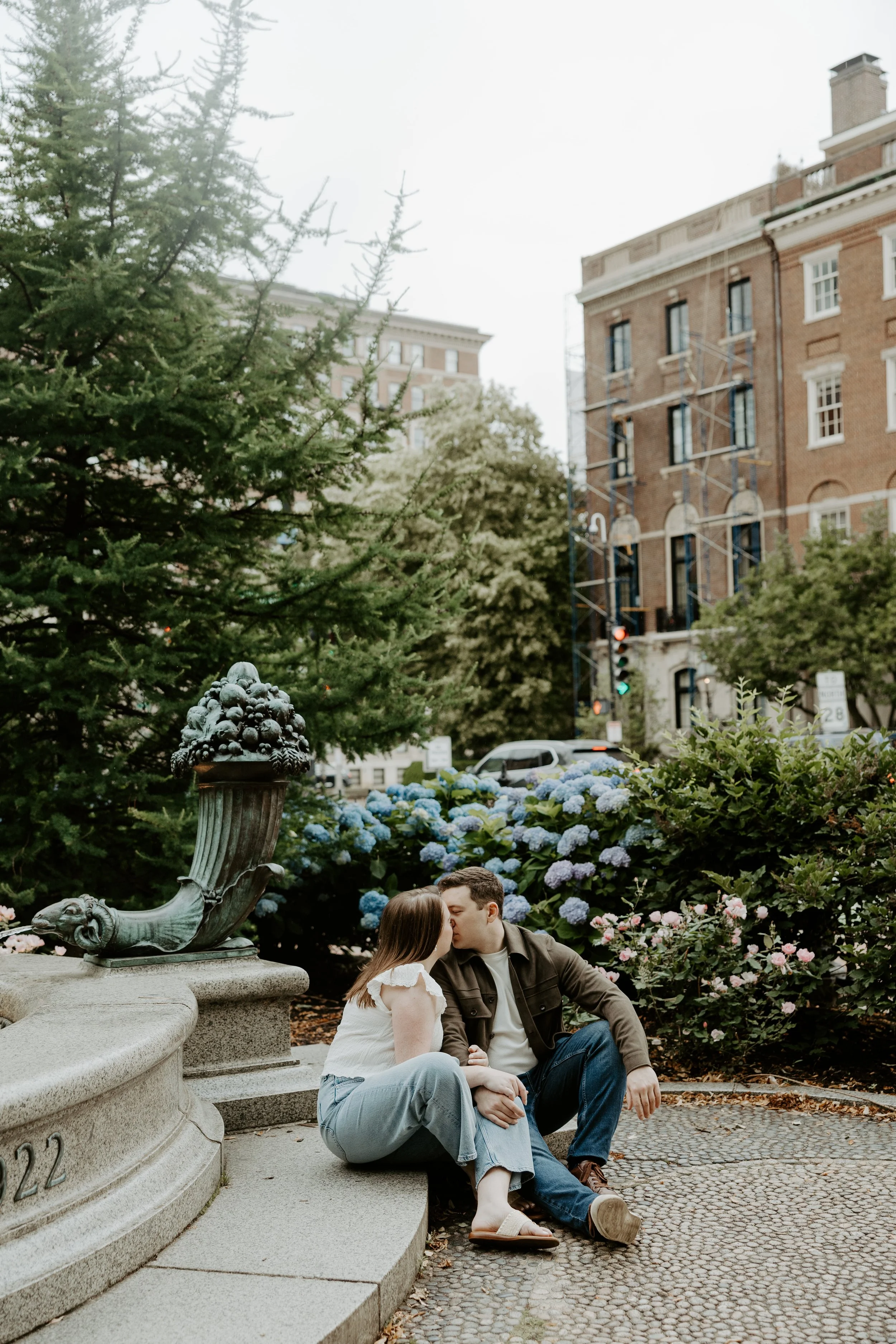 A couple kissing in front of blue flowers in Boston
