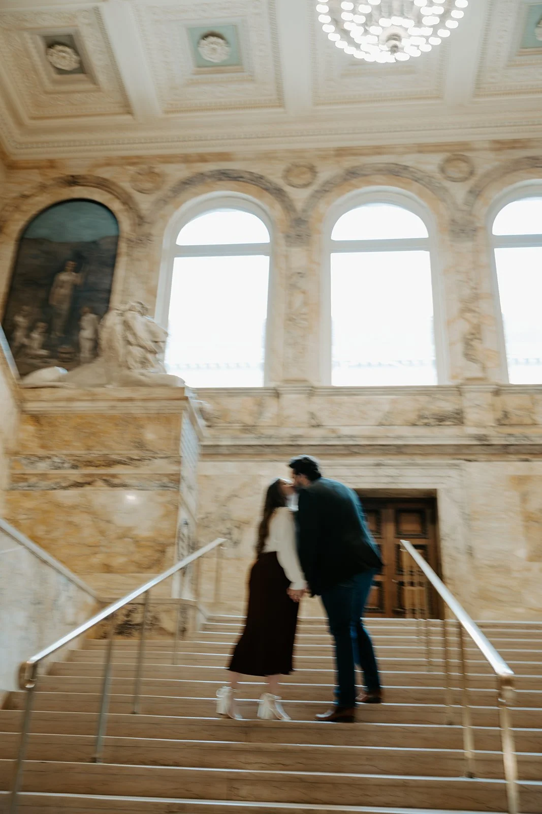 A couple kissing on the stairs of the Boston Public Library