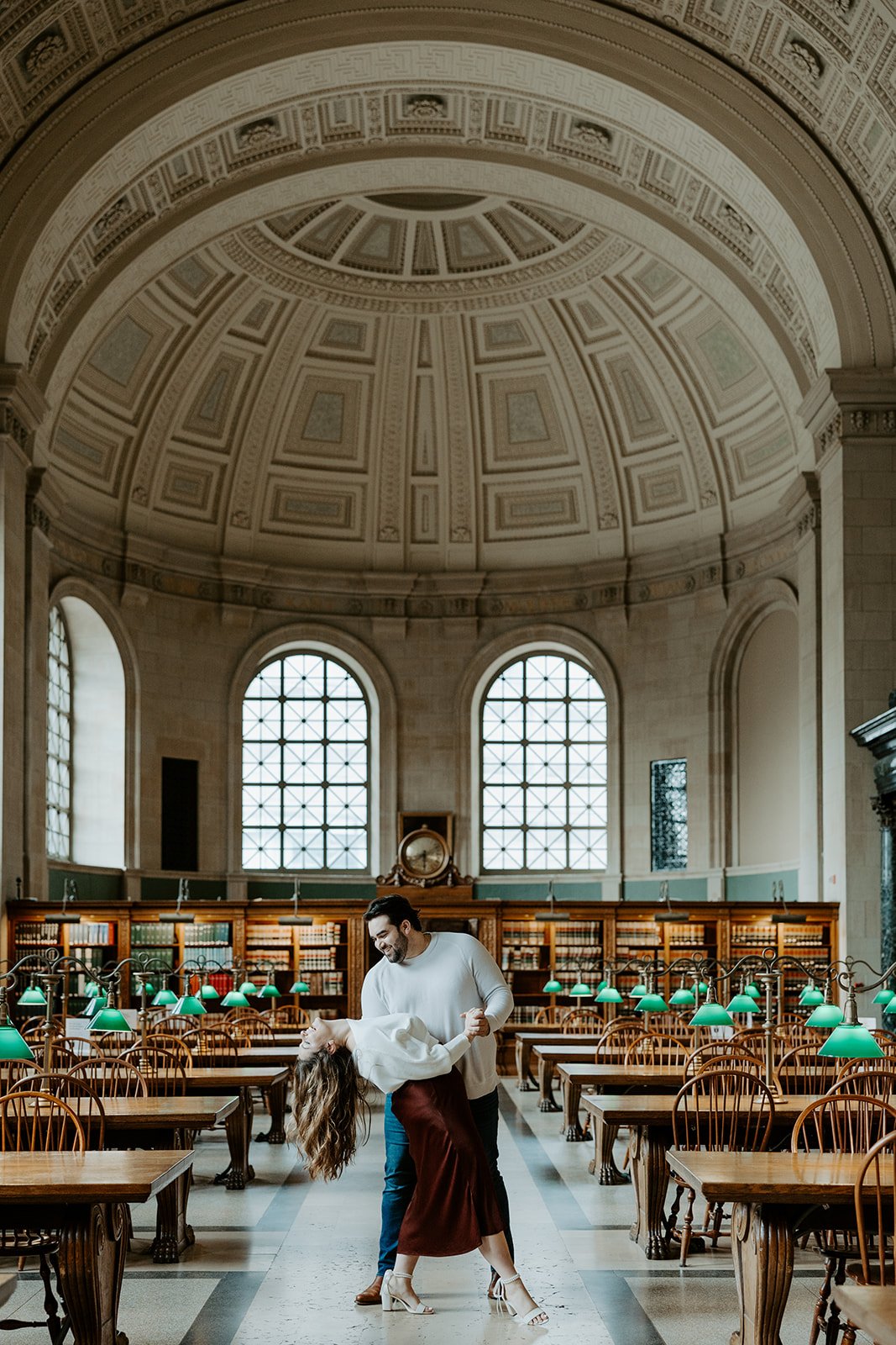 A couple posing for an engagment photoshoot in Boston public library