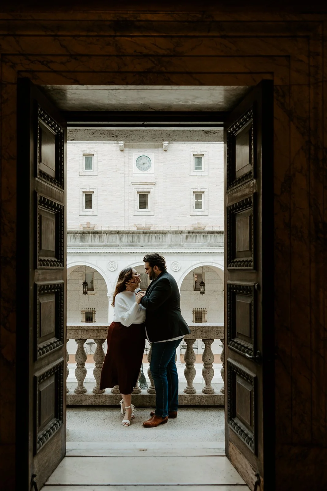 A photo captured of a couple through a door by a Boston engagement photographer