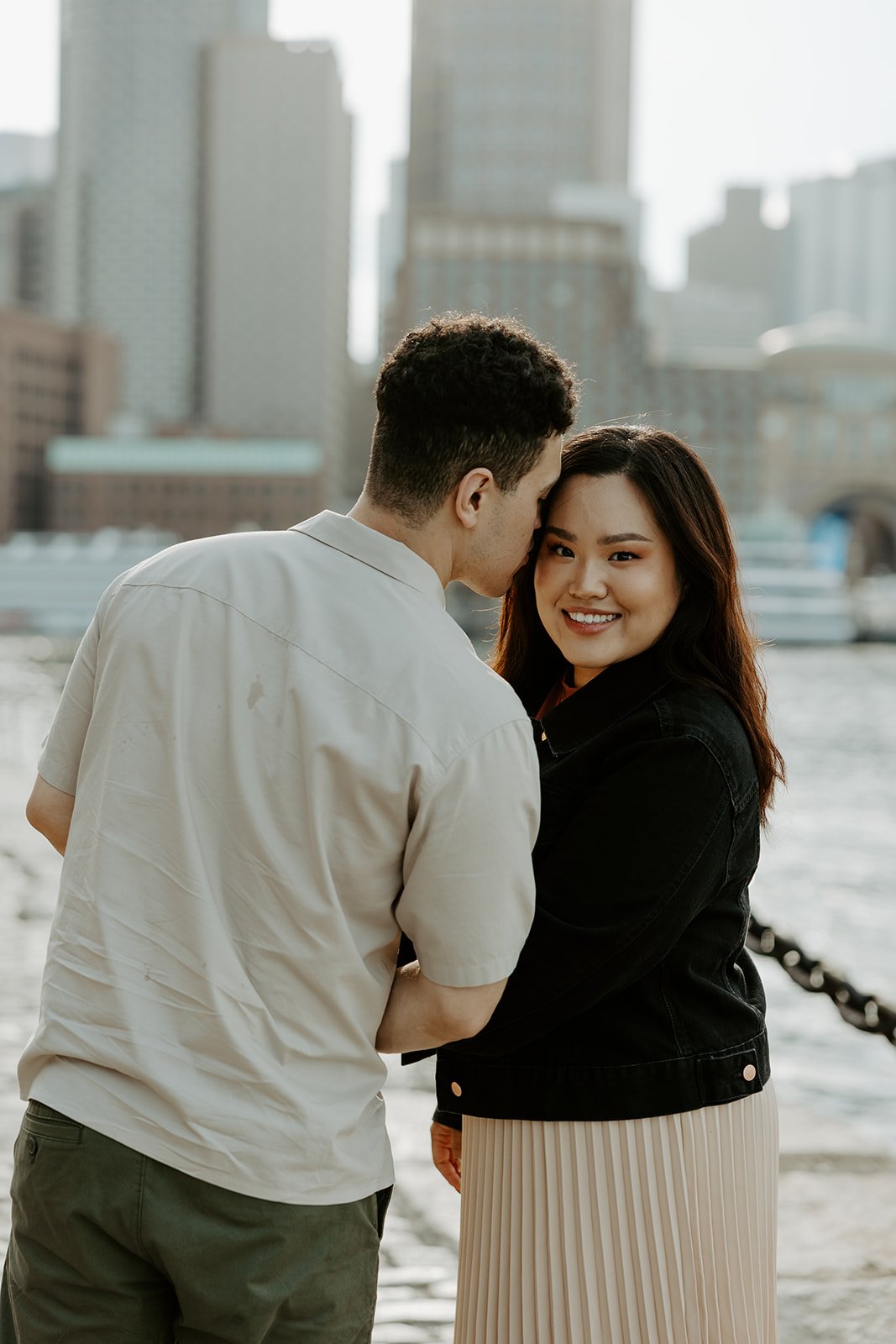 A couple posing for their engagement photoshoot at Fan Pier PArk