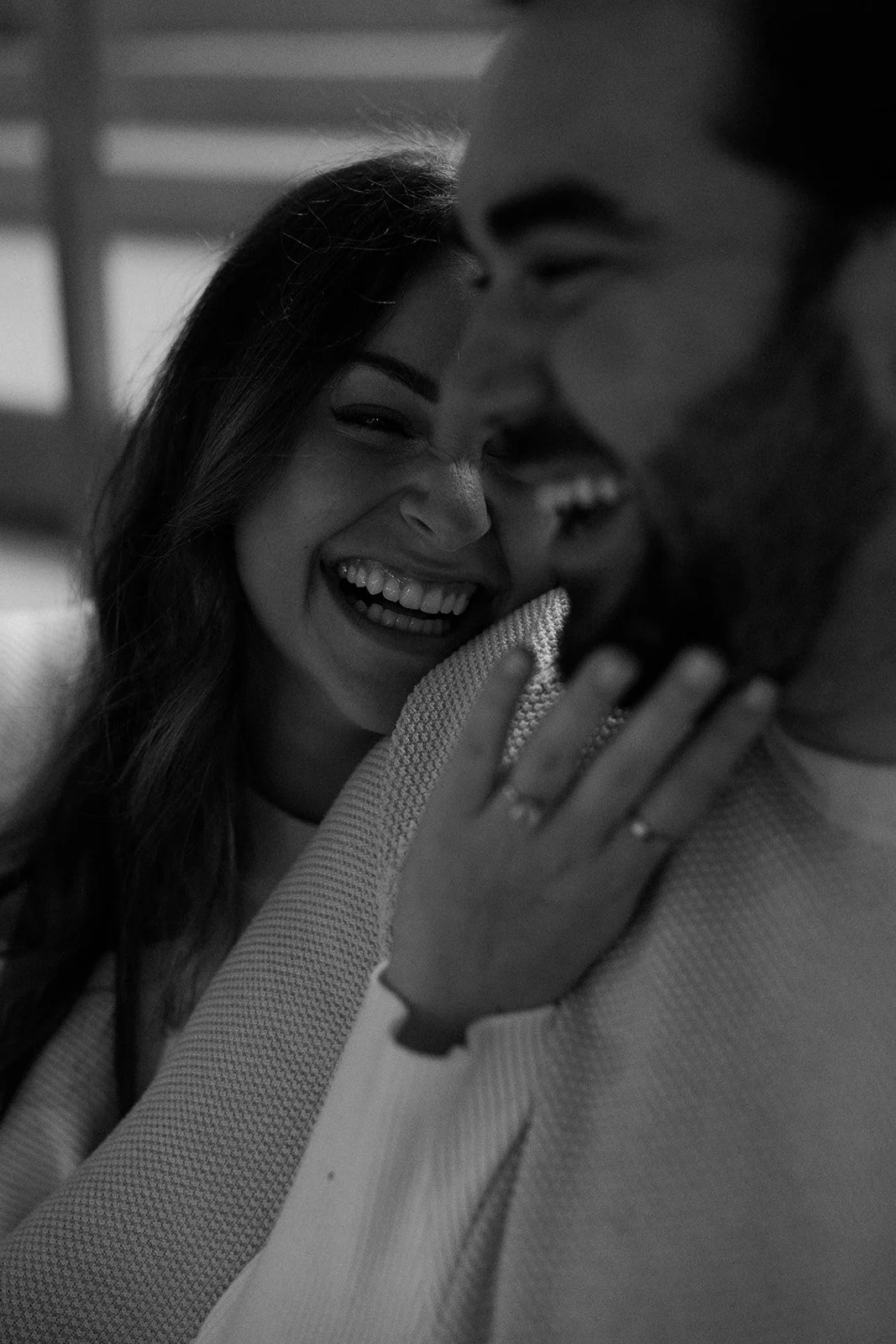 A couple laughing in a black and white engagement photo