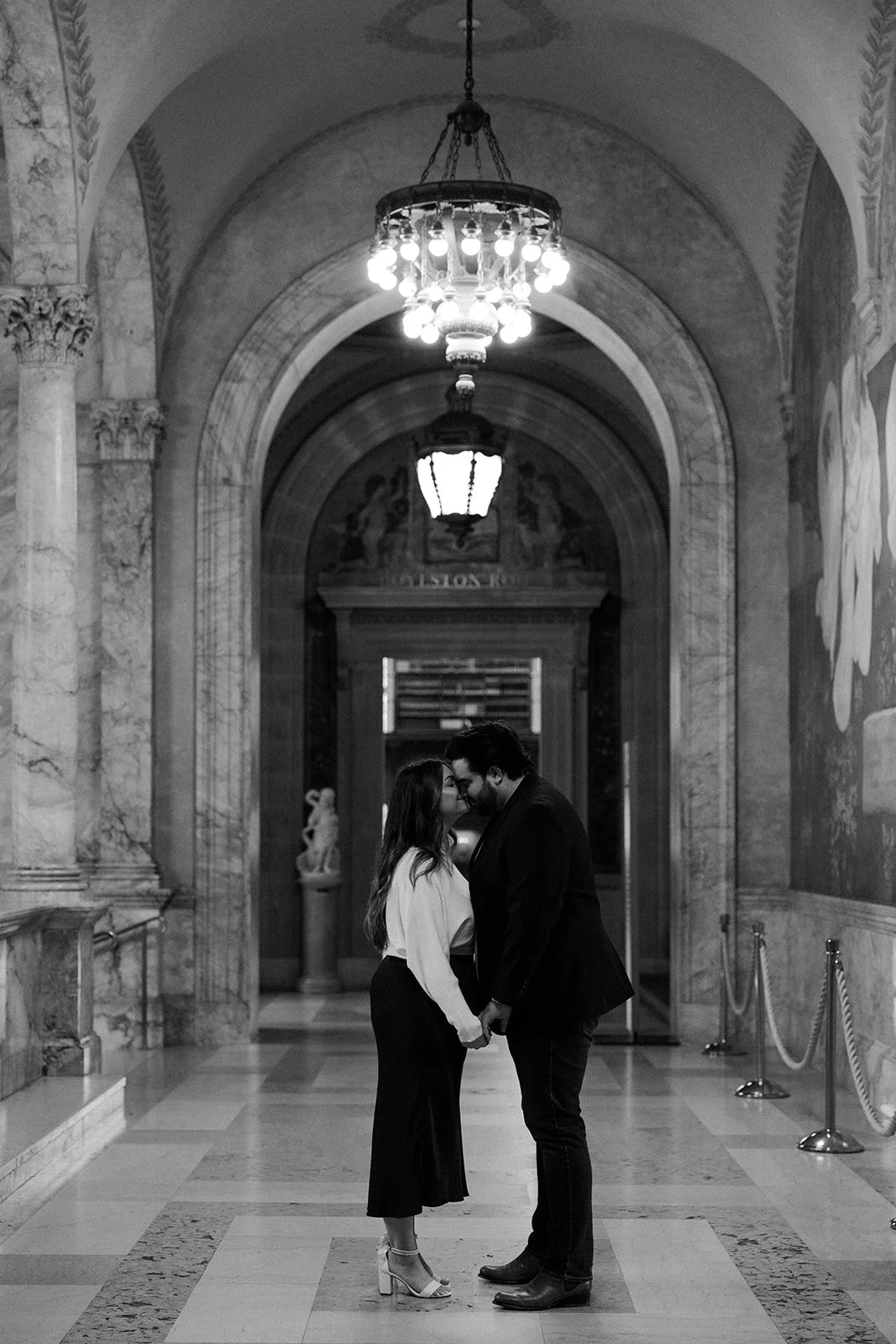 A couple kissing in a hallway for their engagement photoshoot, captured by a Boston engagement photographer