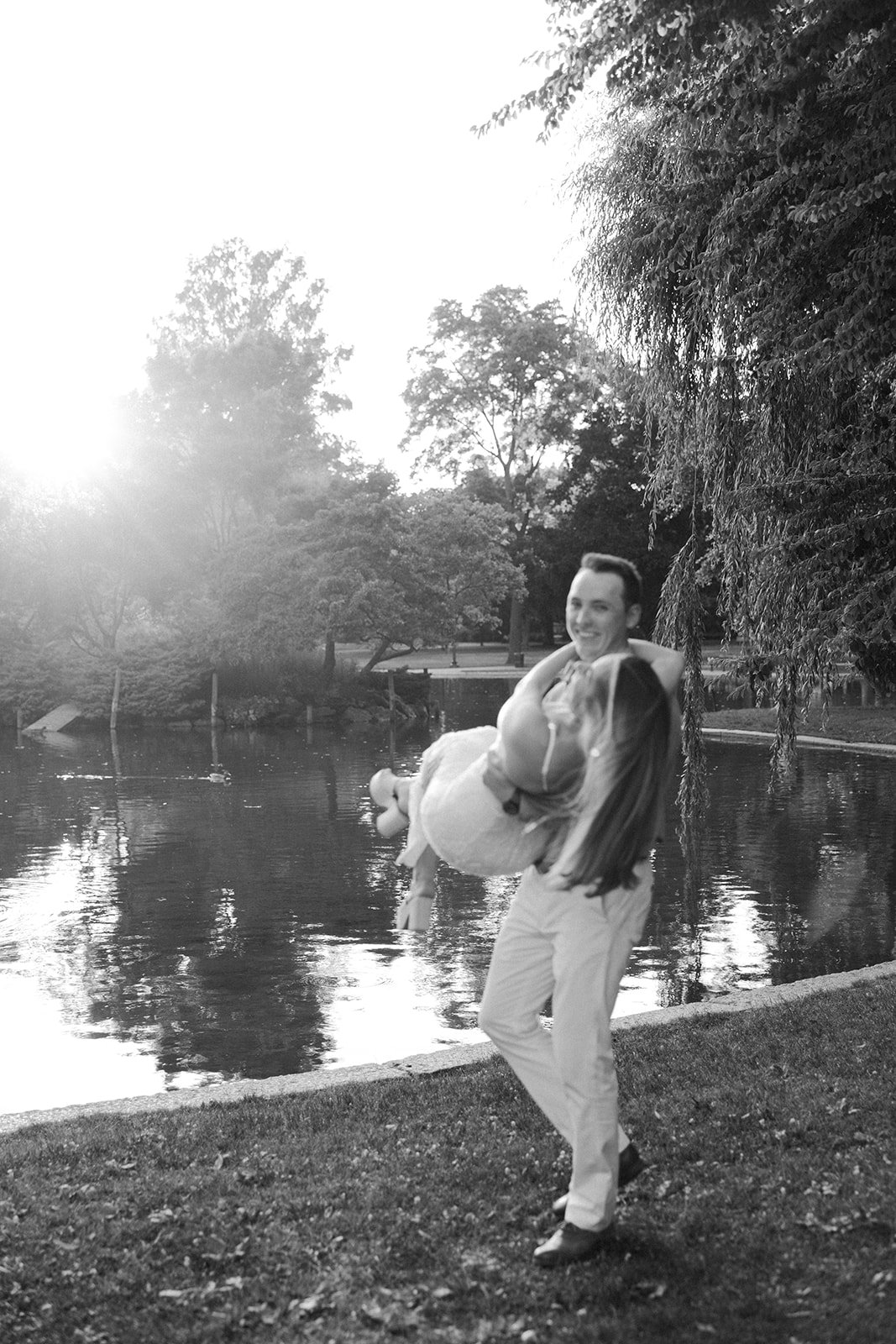 A black and white photo of a man holding and spinning his fiancee