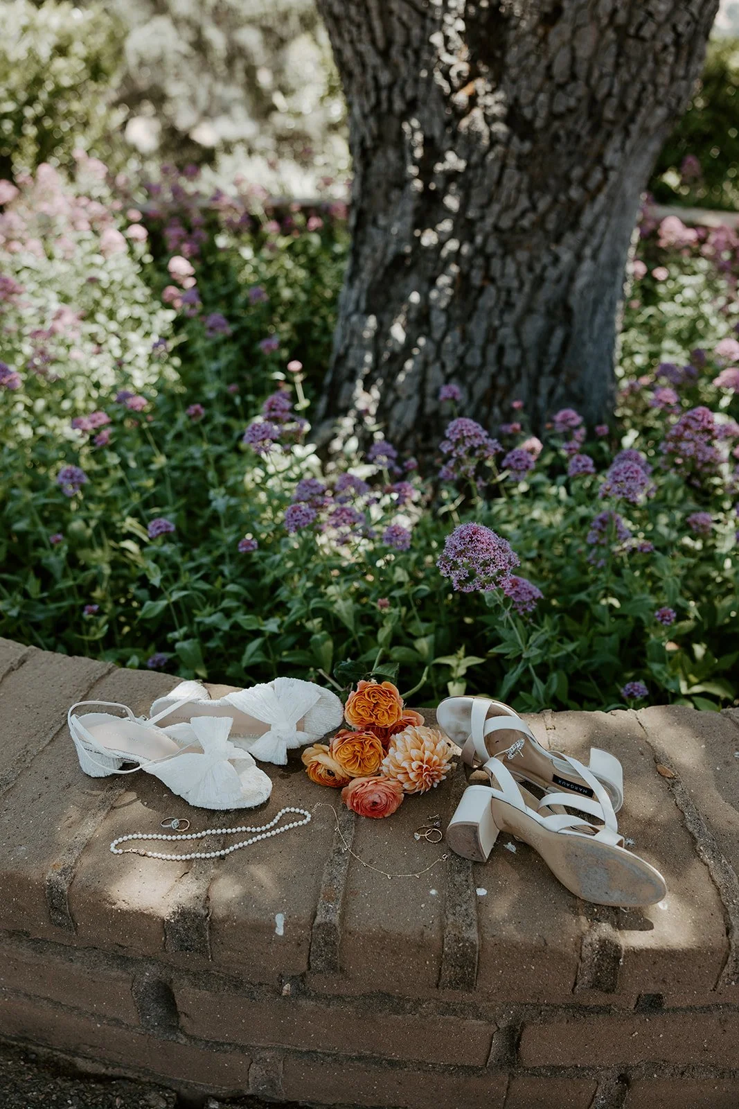 A wedding flatlay from a whimsical wedding with wedding shoes, flowers, and jewelry