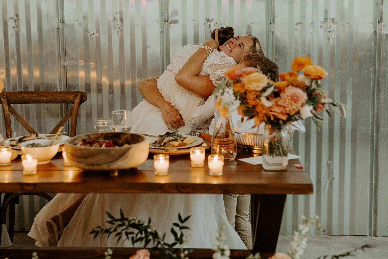 A bride hugging a flower girl after her wedding speech